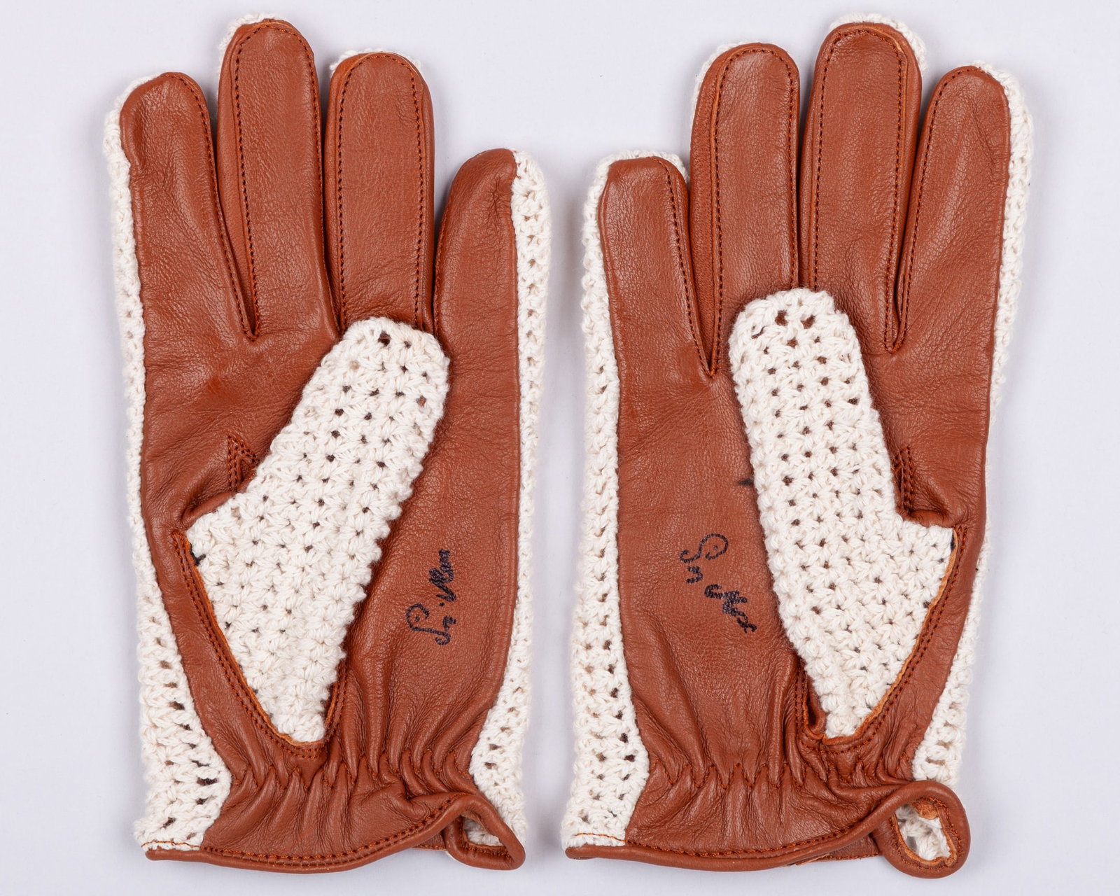 Stirling Moss Signed Replica Gloves: Stirling Moss Signed Replica Gloves.Each glove has been personally signed by legendary British racing driver Sir Stirling Moss.Moss achieved 16 Grand Prix victories and enjoyed a remarkable career spa