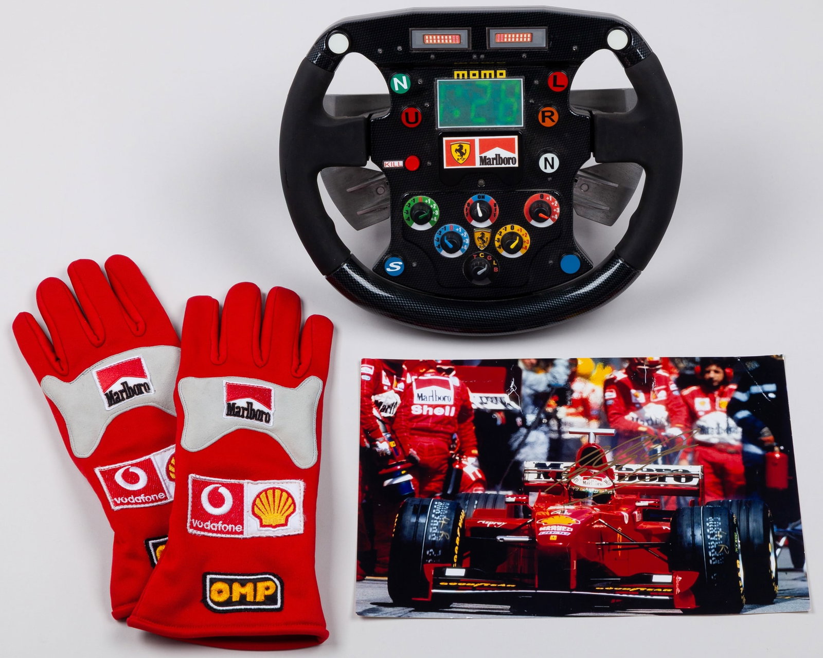 Ferrari 2000 Replica Steering Wheel, OMP Gloves & Signed Michael Schumacher Photo: Ferrari 2000 Replica Steering Wheel, OMP Gloves & Signed Michael Schumacher Photo.This collection represents one of the most dominant seasons in Formula One history ? the Ferrari 2000 Championship Era