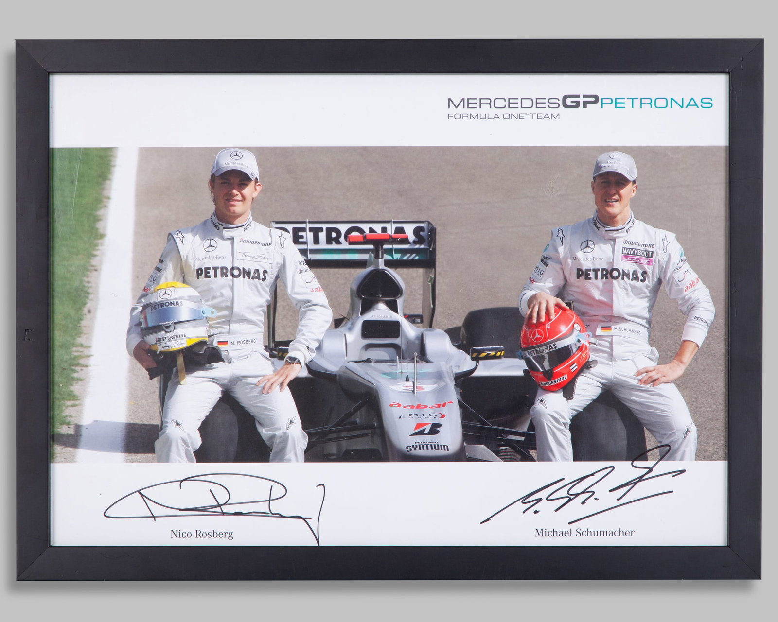 Michael Schumacher & Nico Rosberg Signed Mercedes GP Formula One Team Framed Photo: Michael Schumacher & Nico Rosberg Signed Mercedes GP Petronas Formula One Team Framed Photo.This photo has been personally signed by F1 World Champions Michael Schumacher, and Nico Rosberg.The frame m