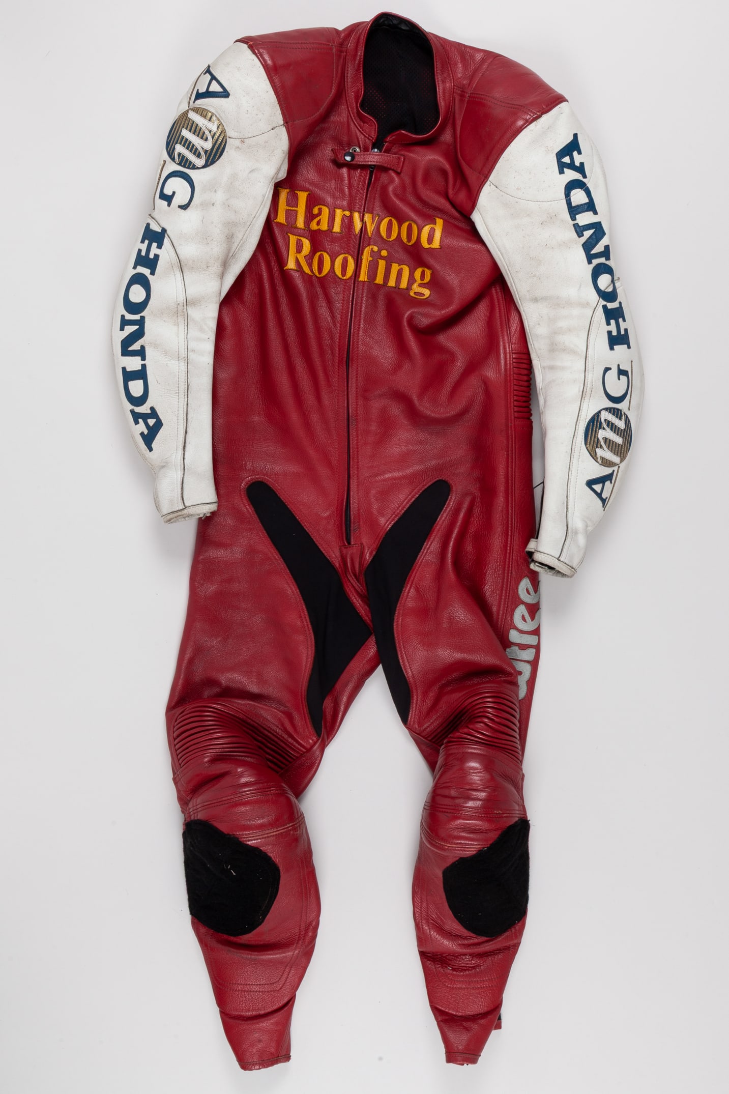 Peter Barker Worn Race Suit: Peter Barker Worn Race Suit.This is an authentic race-worn driving suit used by renowned racer Peter Barker during his competitive motorsport career.The suit displays signs of use consistent with comp