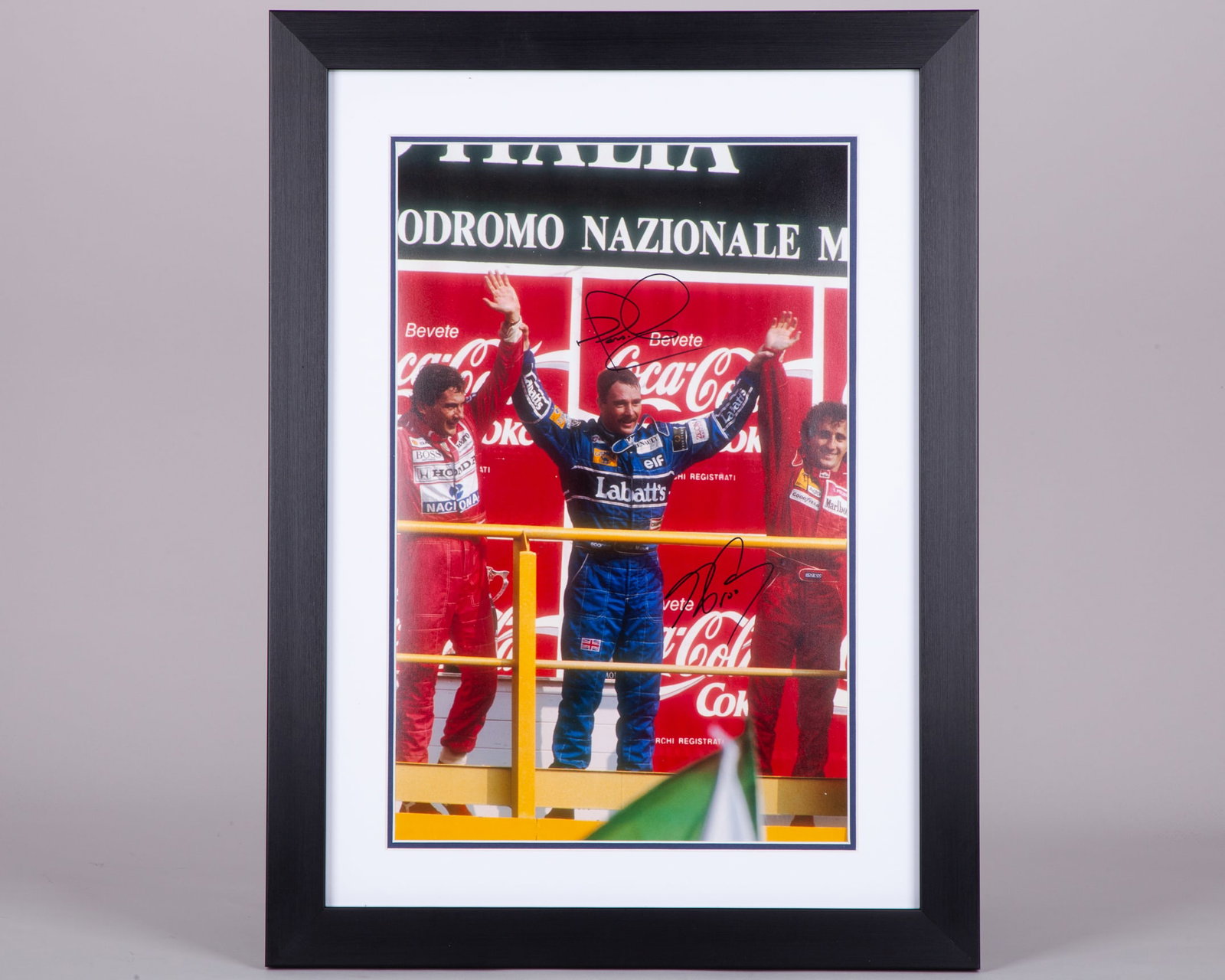 Nigel Mansell & Alain Prost Signed Podium Framed Print: Nigel Mansell & Alain Prost Signed Podium Framed Print.The print is professionally mounted, framed and glazed, and is personally hand signed by Nigel Mansell and Alain Prost.The frame measures 61cm he