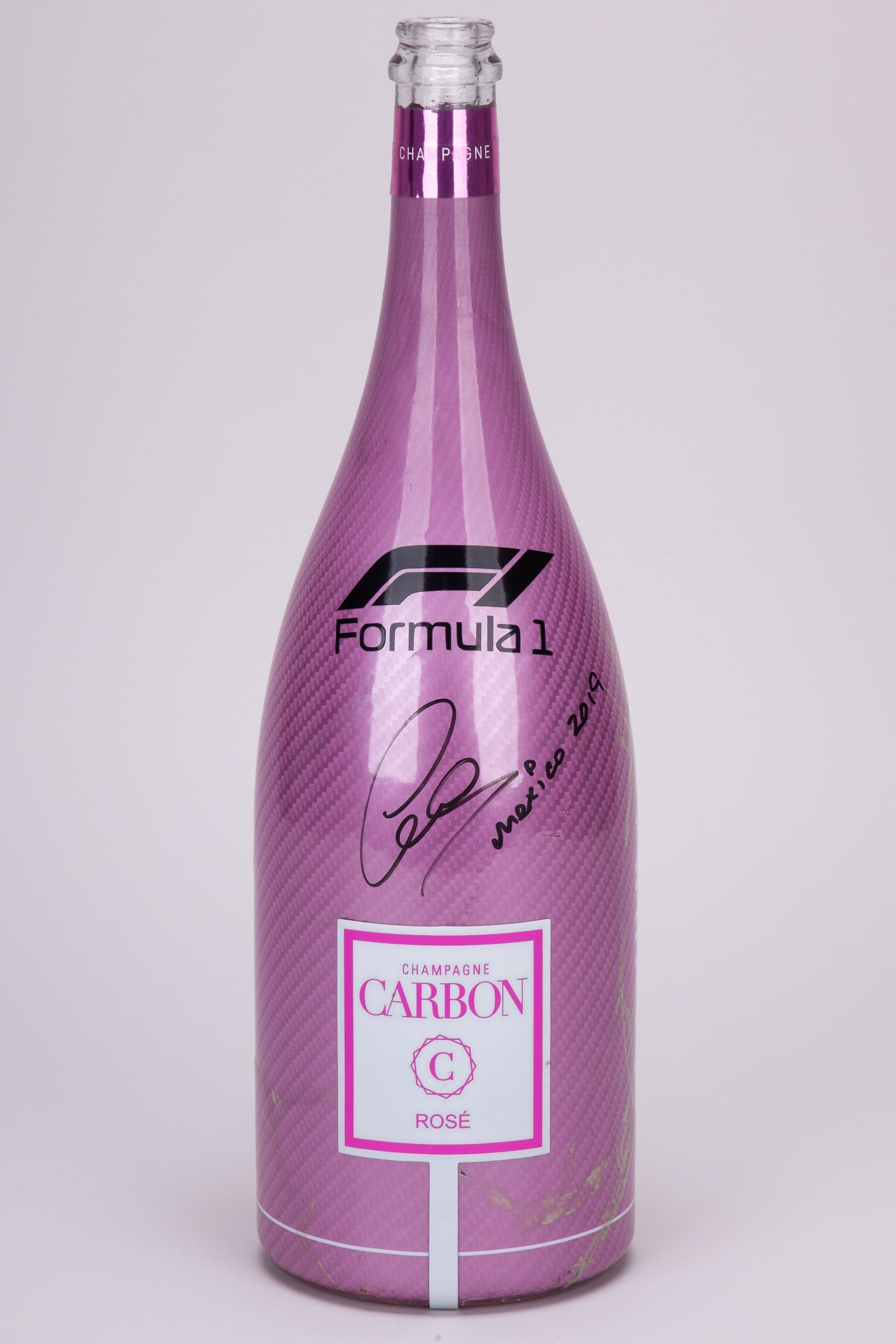 Lewis Hamilton Signed 2019 Mexican Grand Prix Used Carbon Pink Champagne Magnum: Lewis Hamilton Signed 2019 Mexican Grand Prix Used Carbon Pink Champagne Magnum.This is a used (empty) Carbon pink champagne magnum from the F1 Paddock Club, hand signed by Lewis Hamilton.?The bottle 