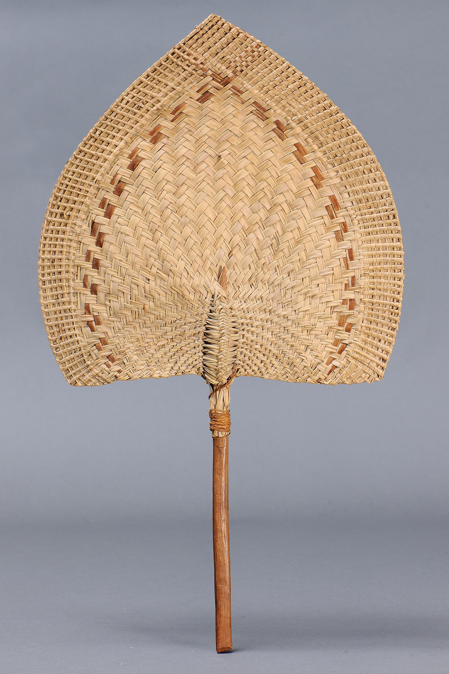 LARGE WOVEN FAN, TONGAN ISLANDS: Large Woven Fan, Tongan Islands. Woven Pandanus Palm Leaf, Coconut Fibre (Textile) & Wood. Size Approx L65 x 37cm. Provenance Private collection, Melbourne, Victoria Literature The lots in this