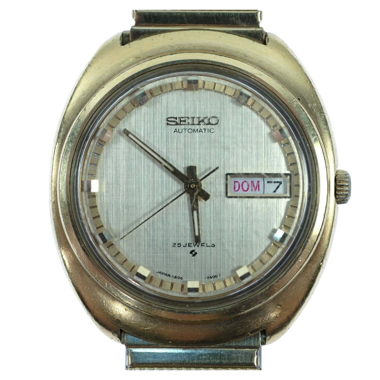 Vintage Men's Seiko Wristwatch with Gold Case & Silver Dial: Model# 5606 - 7170. Day & Date Function. Metal Gold Expander Band Size Case approx 36mm Condition Automatic. Working. Glass is scuffed Medium Vintage