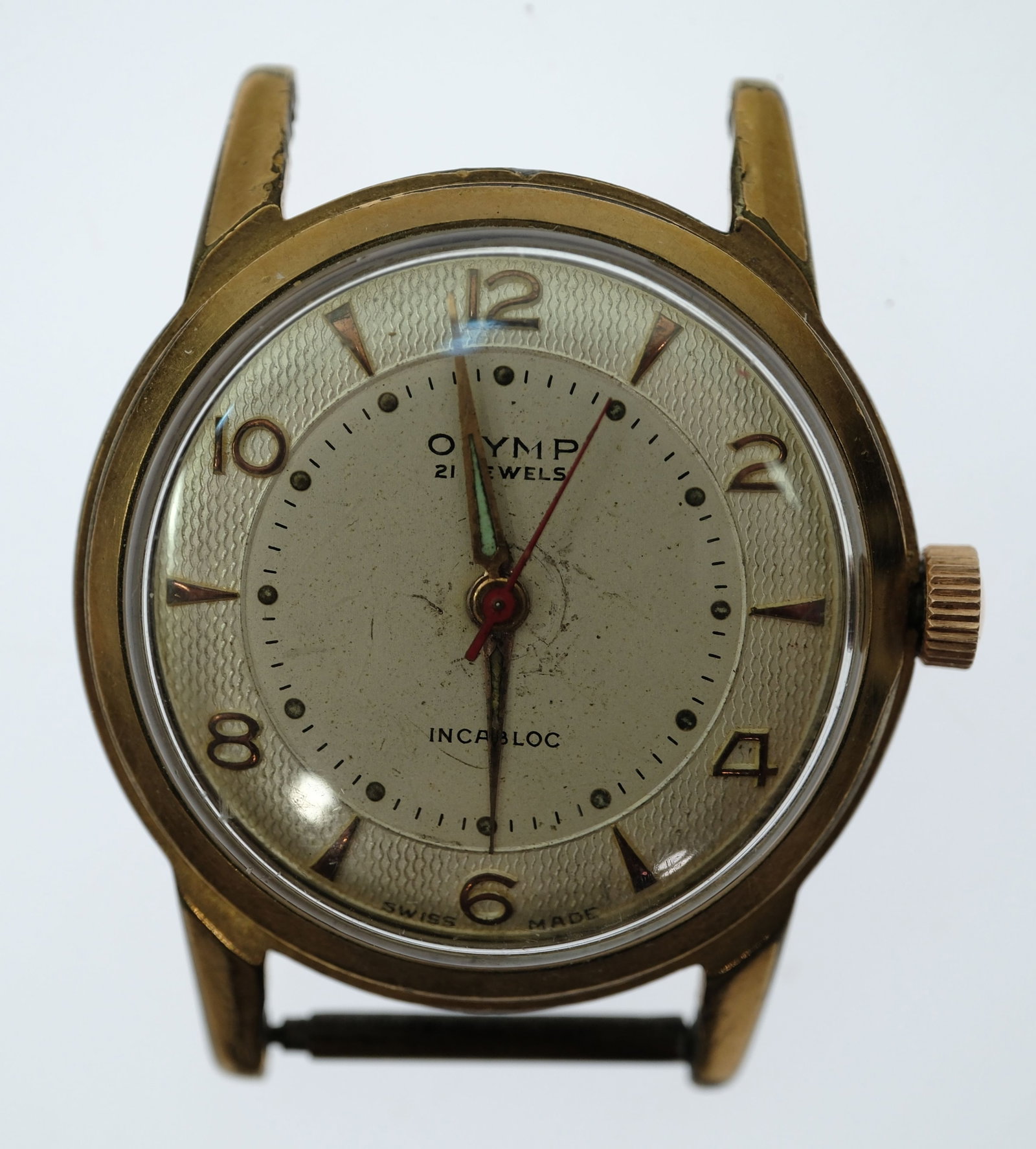 Vintage Boy's Olymp(ic) 'Invicta' Wristwatch with Gold Case & Machine patterned Silver Dial: Model# 22781. 21 Jewels. No Band. The 'Olymp' Brand was registered in 1953 by the Sydney watch importer Charles Spring. Spring imported generic catalogue watches sourced from Switzerland, which he cus
