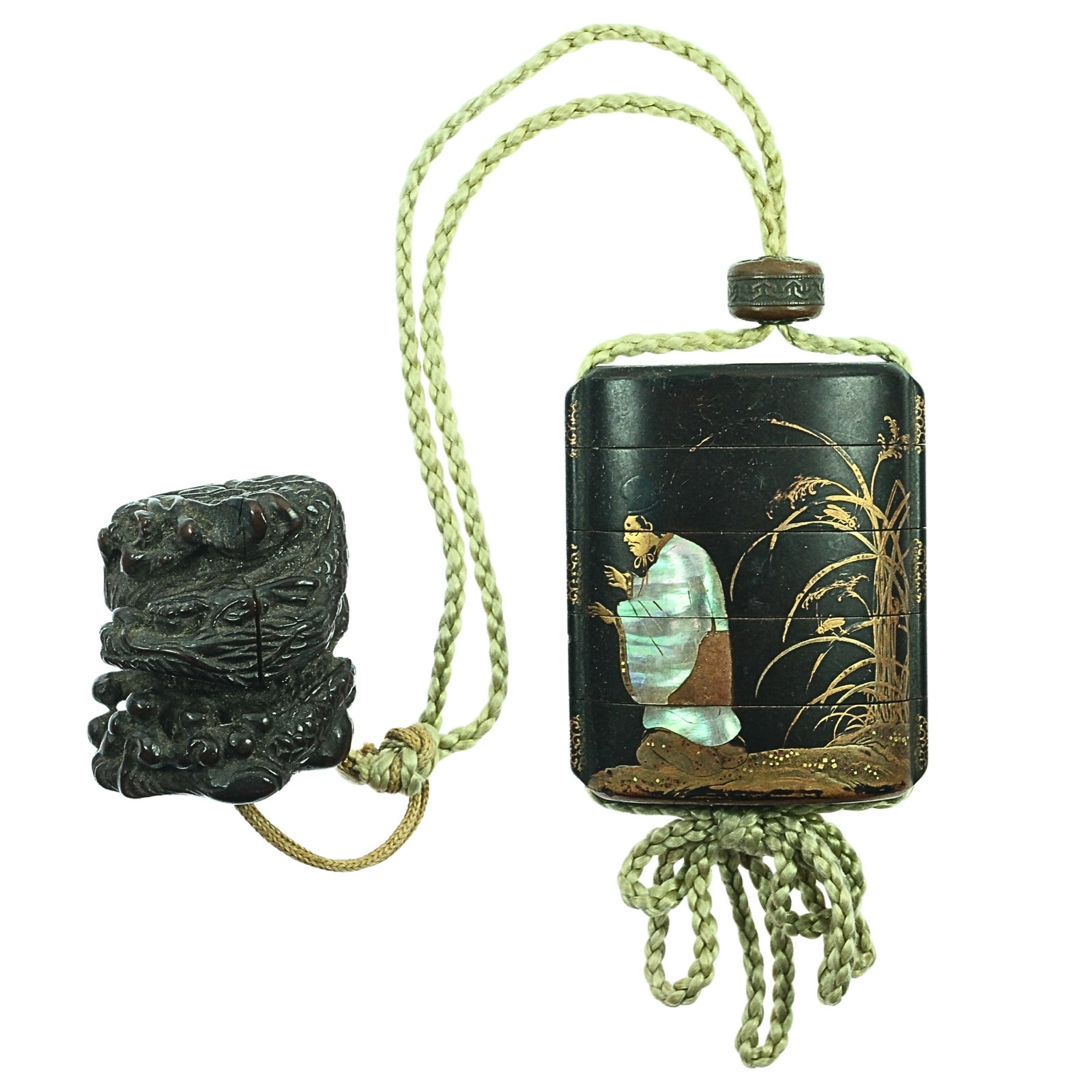 Vintage Japanese Inro decorated with Male & Female figures & tethered to Wooden Netsuke of a Dragon: Inro were connecting sections of boxes used to carry small items such as personal seals and medicines. The inrō is secured by an ojime bead and tethered to a netsuke, which is hung from a belt Si