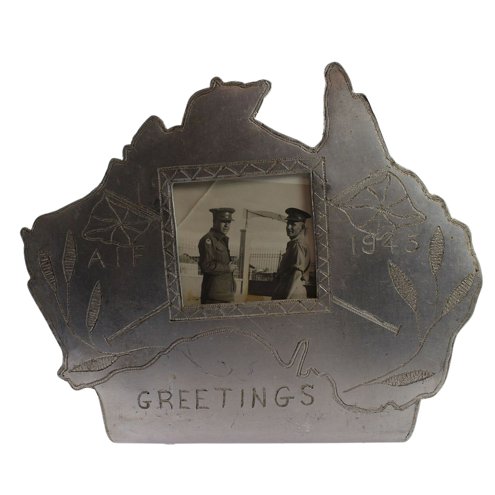 Australia - WWII Trench Art Photo Frame made from aluminium Aircraft Fuselage: A cut-out Map of Australia engraved 'AIF / 1943 / Greetings" A complementary piece to the following lot and could be combined as a pair of bookends. Size Stand 12cms Medium Collectibles