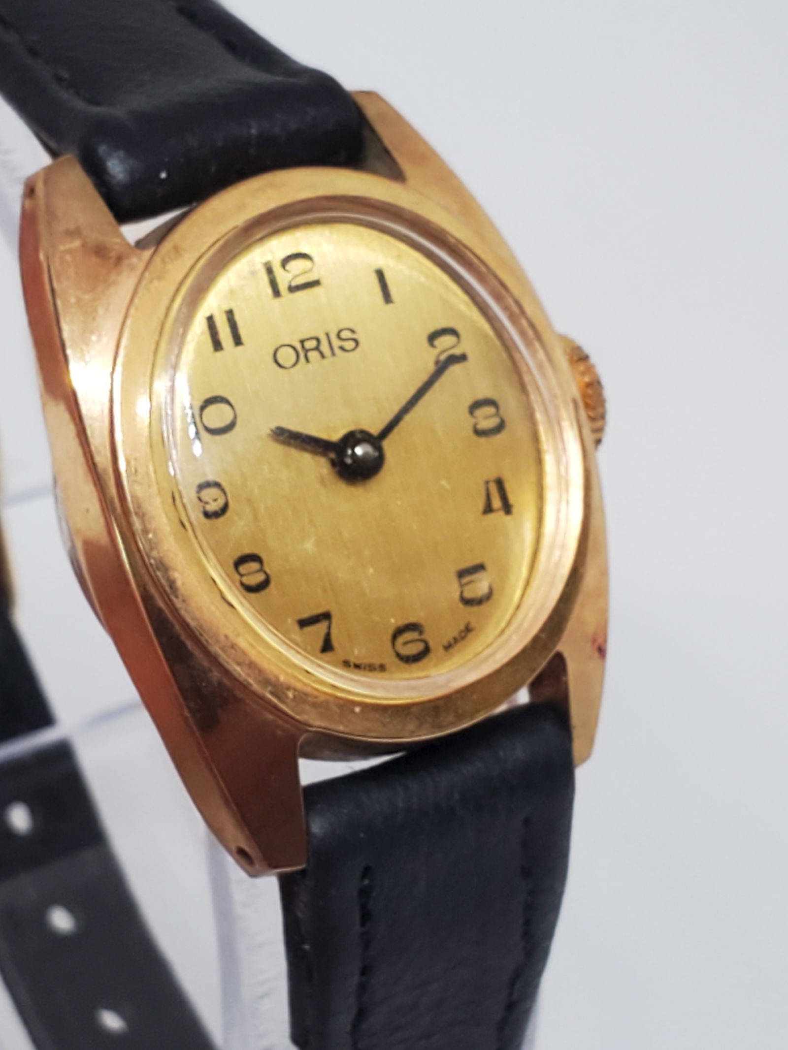Oris Gold Plated Watch, Manual, 1960s: Working condition Oris luxury timepiece, an exquisite blend of vintage charm and sophisticated craftsmanship. With its oval, gold-plated case and classic gold dial adorned with striking black numerals