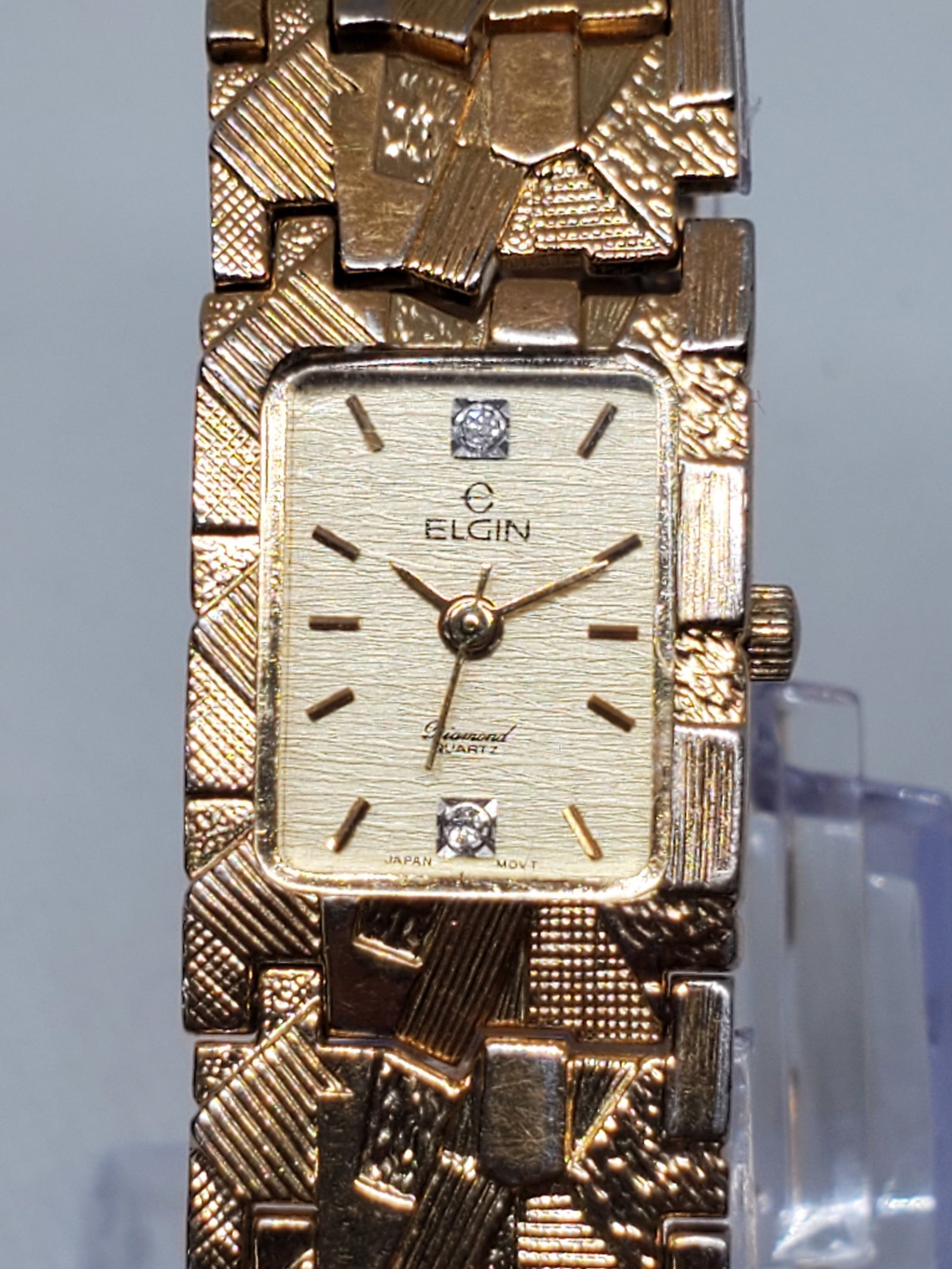 Elgin Gold Plated Ladies Watch With Diamonds, 1990s: Discover refined elegance with this Elgin EM503 017 dress watch, designed for those who appreciate timeless luxury. The gold plated case frames a radiant gold dial adorned with diamond hour markers, o