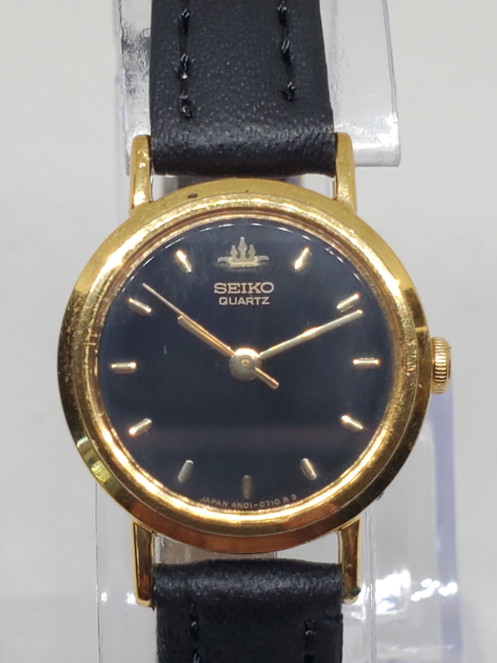 Vintage Seiko 4N01 0300 Quartz Gold Plated Black Dial Dress Watch Japan, circa 1991 to 1993: This elegant Seiko 4N01 0300 Quartz watch showcases the timeless refinement that defines the Seiko brand. Featuring a gold plated round case paired with a deep black dial and gold tone hour markers, i