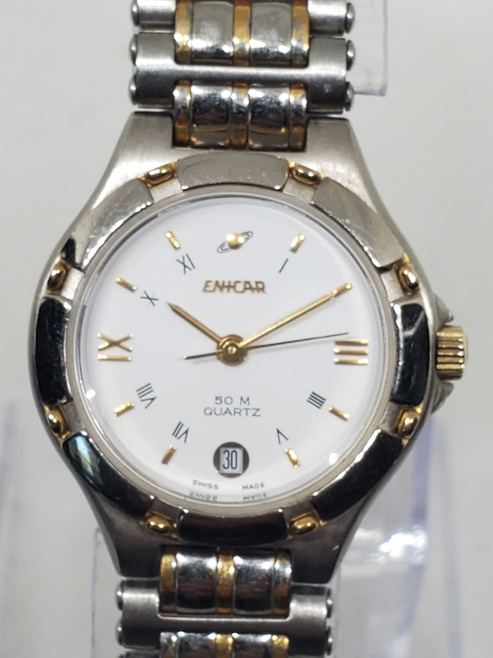 Vintage Enicar 956.387 Swiss Quartz Dress Watch White Dial Two Tone Bracelet, 1990s: This elegant Enicar 956.387 embodies Swiss precision and refined design, featuring a silver tone stainless-steel case complemented by a polished white dial with gold-tone Roman numeral and baton hour
