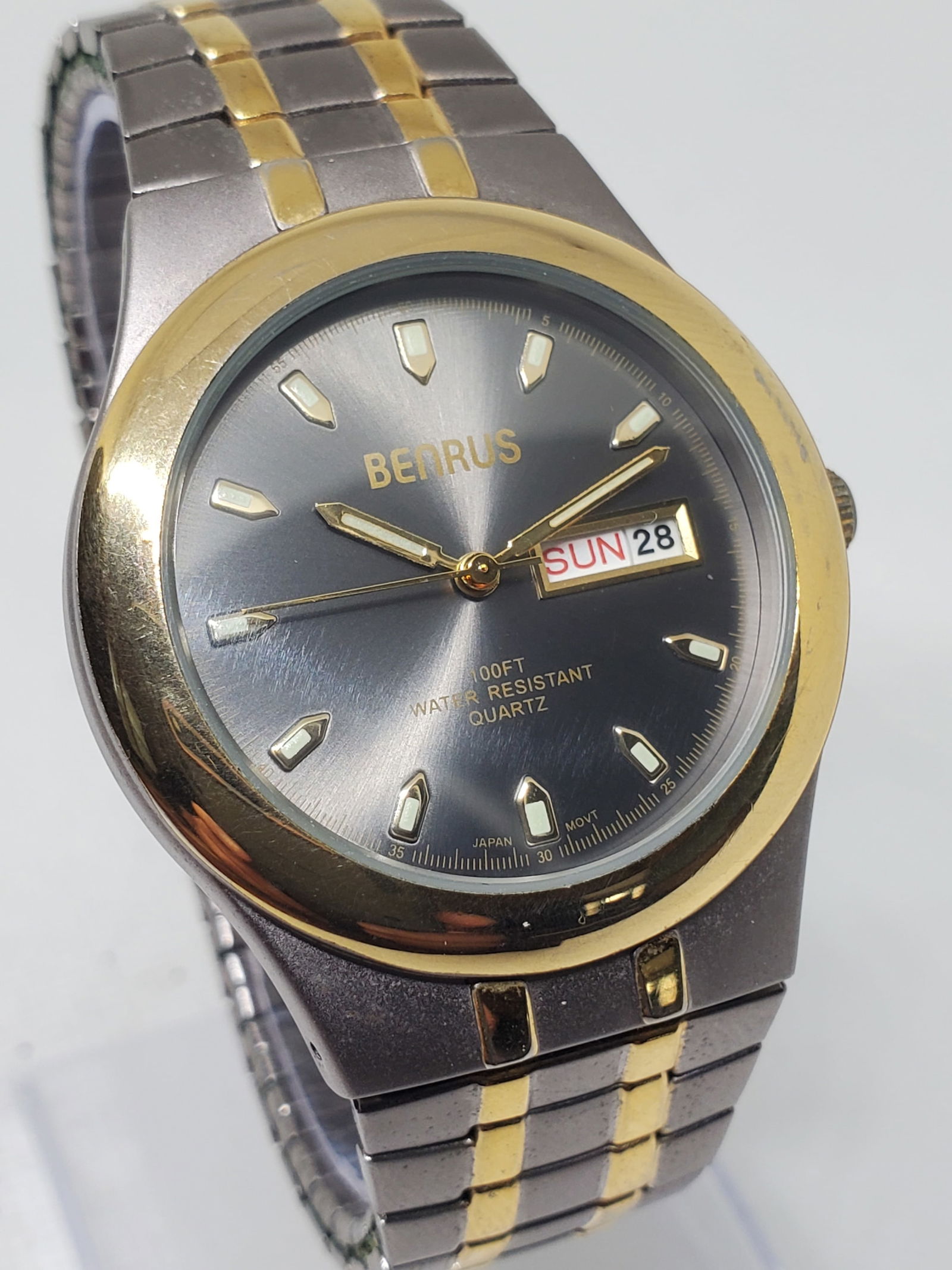 Benrus BNW747 Dual Tone Quartz Watch Day Date 100ft Japan Movt, 1990s: This Benrus BNW747 quartz watch presents a refined balance of elegance and everyday practicality, featuring a silver tone stainless steel case paired with a gold tone bezel that frames a dark gray sun