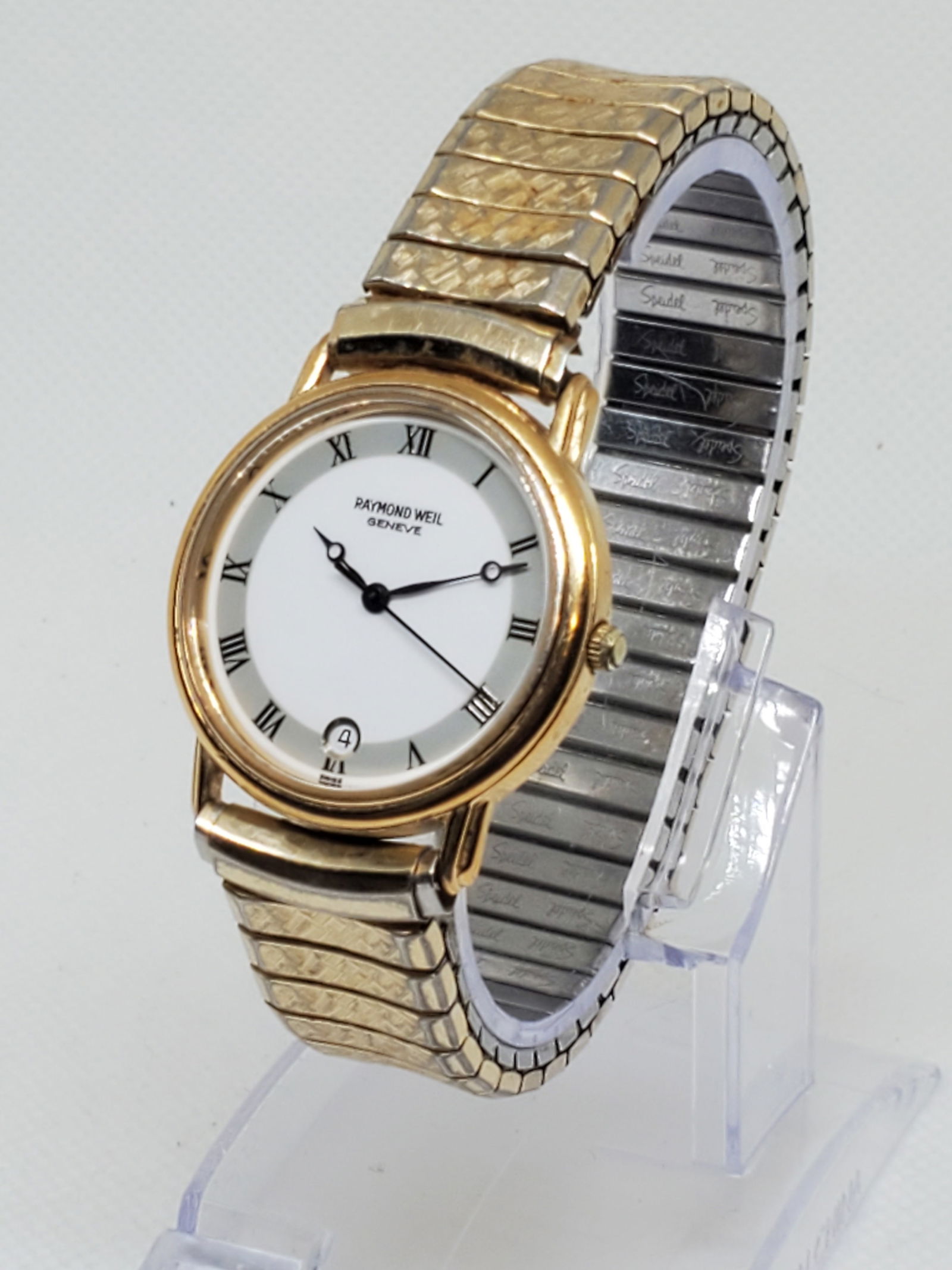 Raymond Weil Geneve 18K Gold Plated Watch, 1990s: Elevate your collection with this elegant Raymond Weil Gen?ve quartz dress watch, featuring a refined 31mm 18K gold plated case, crisp white dial with date window, and a 7? metallic Speidel bracelet.