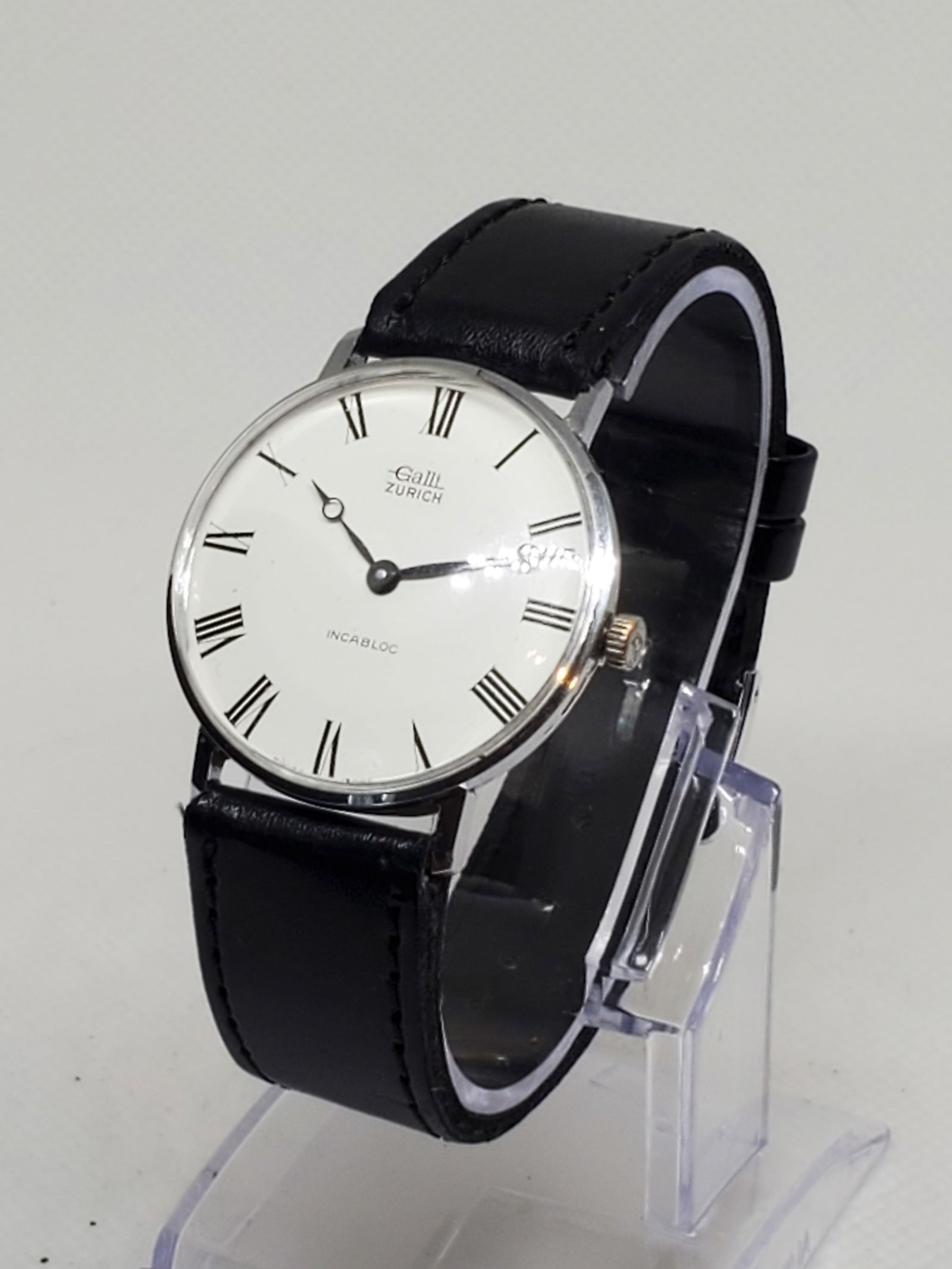 Vintage Galli Zurich Incabloc Manual Swiss Watch Elegant Roman Dial 33mm, late 1960s: This vintage Galli Zurich Incabloc watch embodies timeless Swiss elegance and craftsmanship. Featuring a silvertone stainless steel case with a pristine white dial and classic black Roman numerals, th