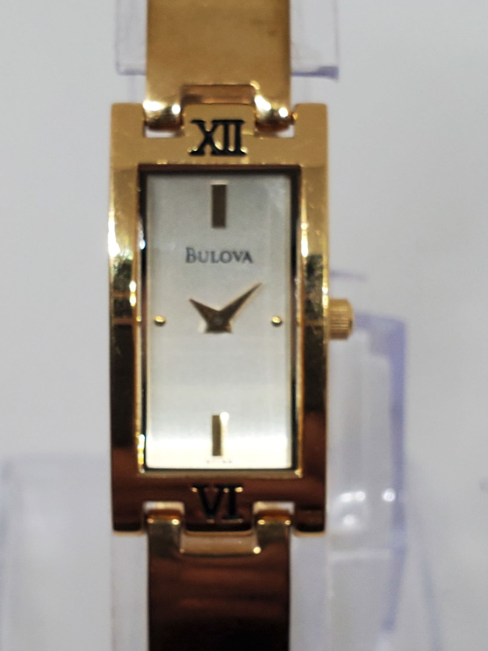 Bulova Classic Bangle Women?s Gold Plated Watch 15x30mm, 1990s: Elegant Bulova Classic Bangle Quartz watch featuring a gold plated case, brushed silver dial, and metallic 7? bracelet. With a refined 15x30mm design, this pristine condition dress watch embodies the