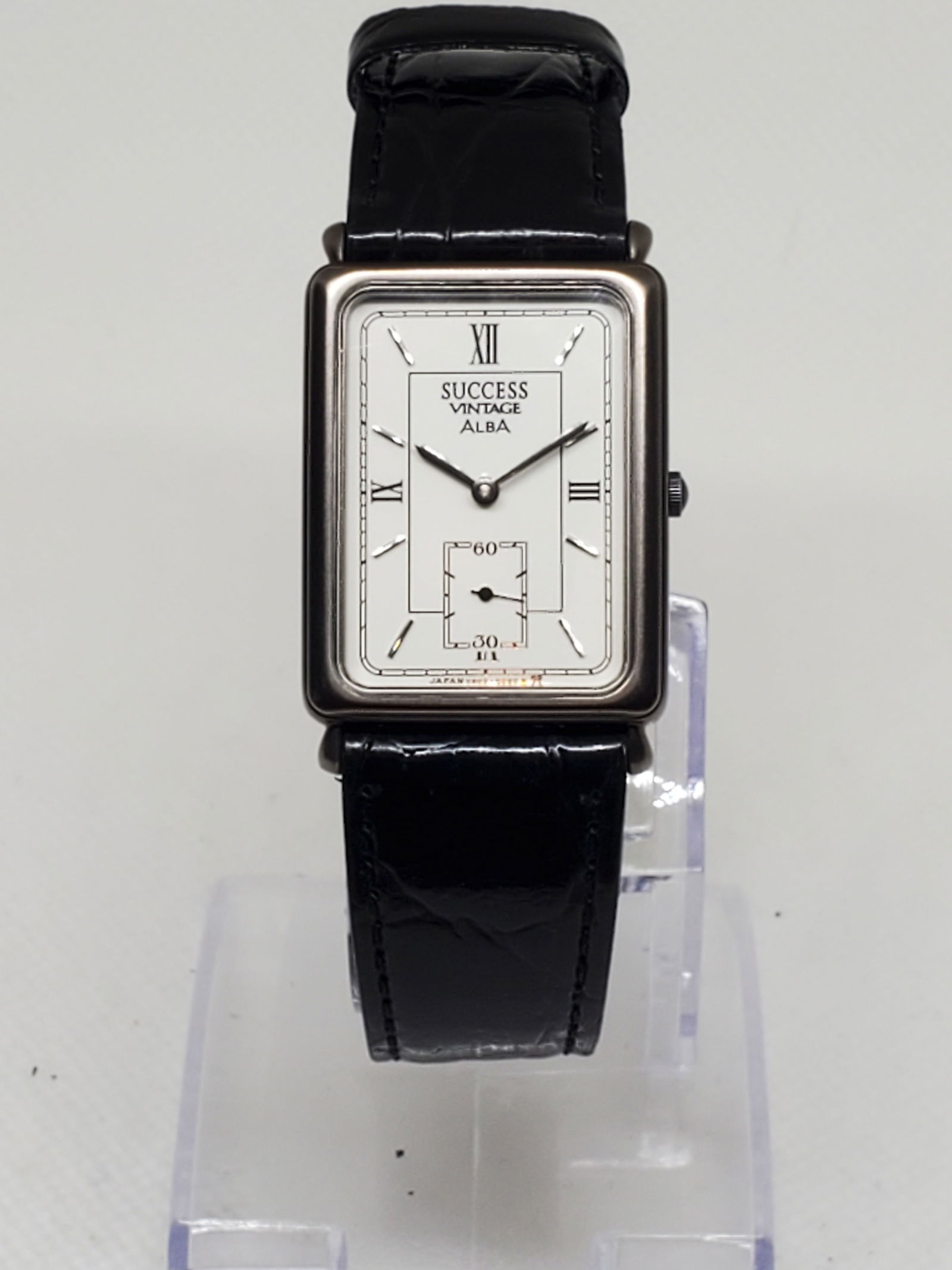 Seiko Alba Success Vintage Rectangular Quartz Watch V803 5000 Japan, 1990s: This Seiko Alba Success Vintage model V803 5000 showcases Seiko?s refined balance of elegance and precision. The rectangular black tone tank case frames a pristine white dial with Roman numerals and a