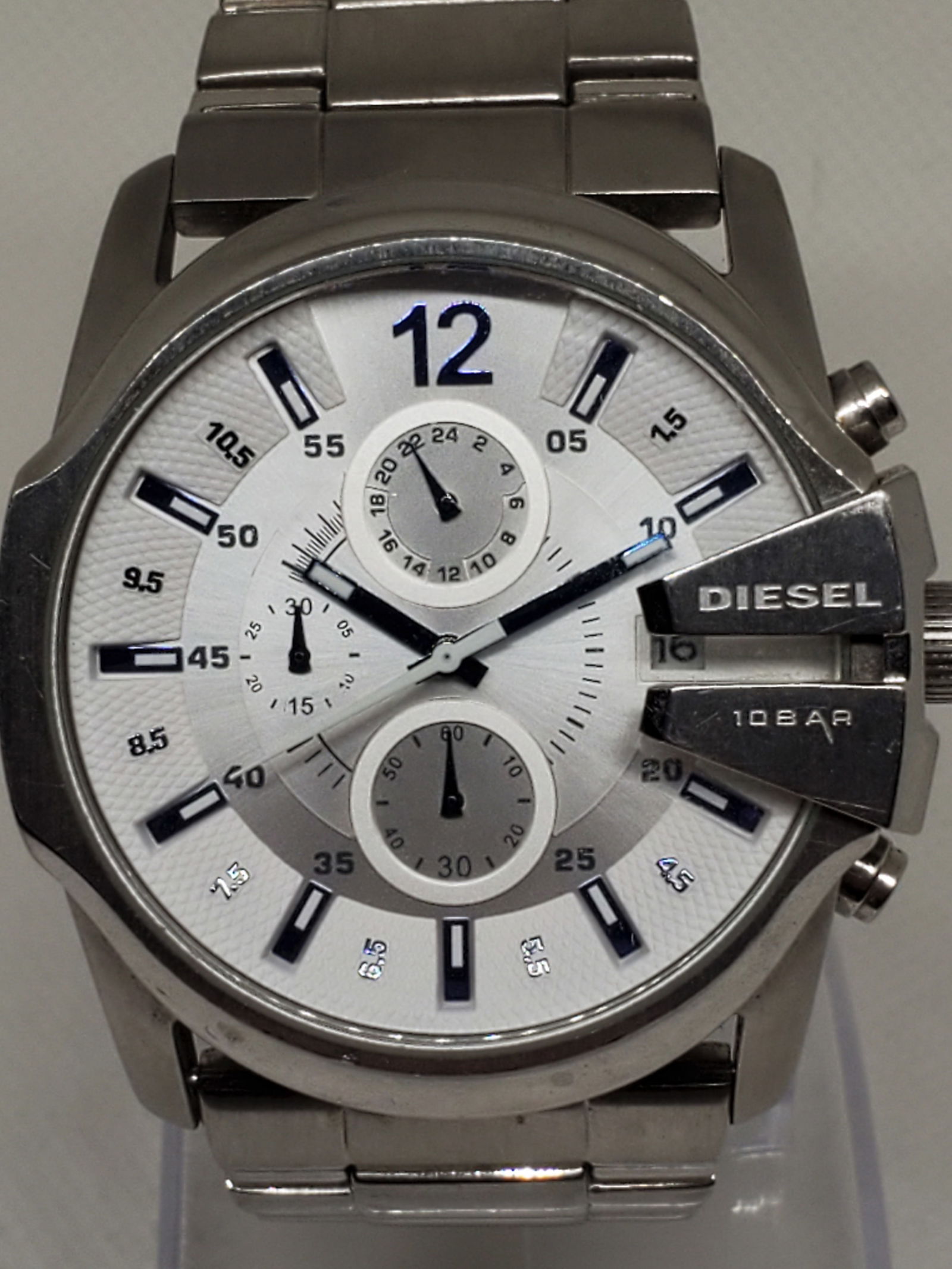 Diesel DZ4181 Chronograph Sport 46mm, White Dial: This Diesel DZ4181 chronograph watch is a bold and stylish timepiece that reflects the brand?s signature blend of modern design and durability. Featuring a silver tone stainless steel case and bracele