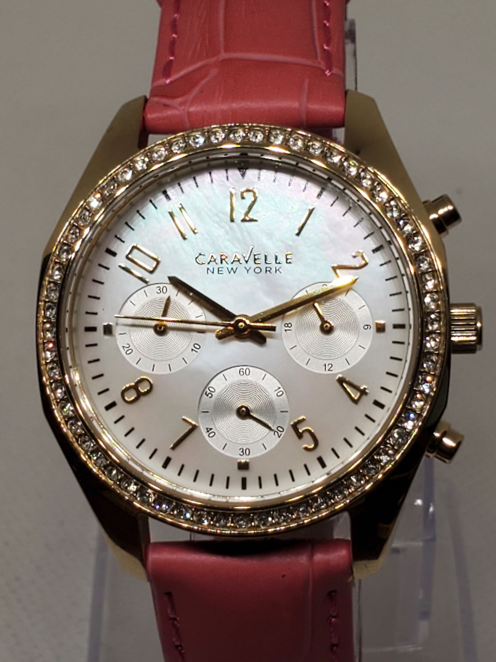 Bulova Caravelle Gold Tone Chronograph Mother of Pearl with Rhinestones, new in box, 2010s: Working condition Bulova Caravelle 44L169, a watch that seamlessly blends sophistication with functionality. Featuring a gold tone case and a luxurious mother of pearl dial, this stunning piece also i
