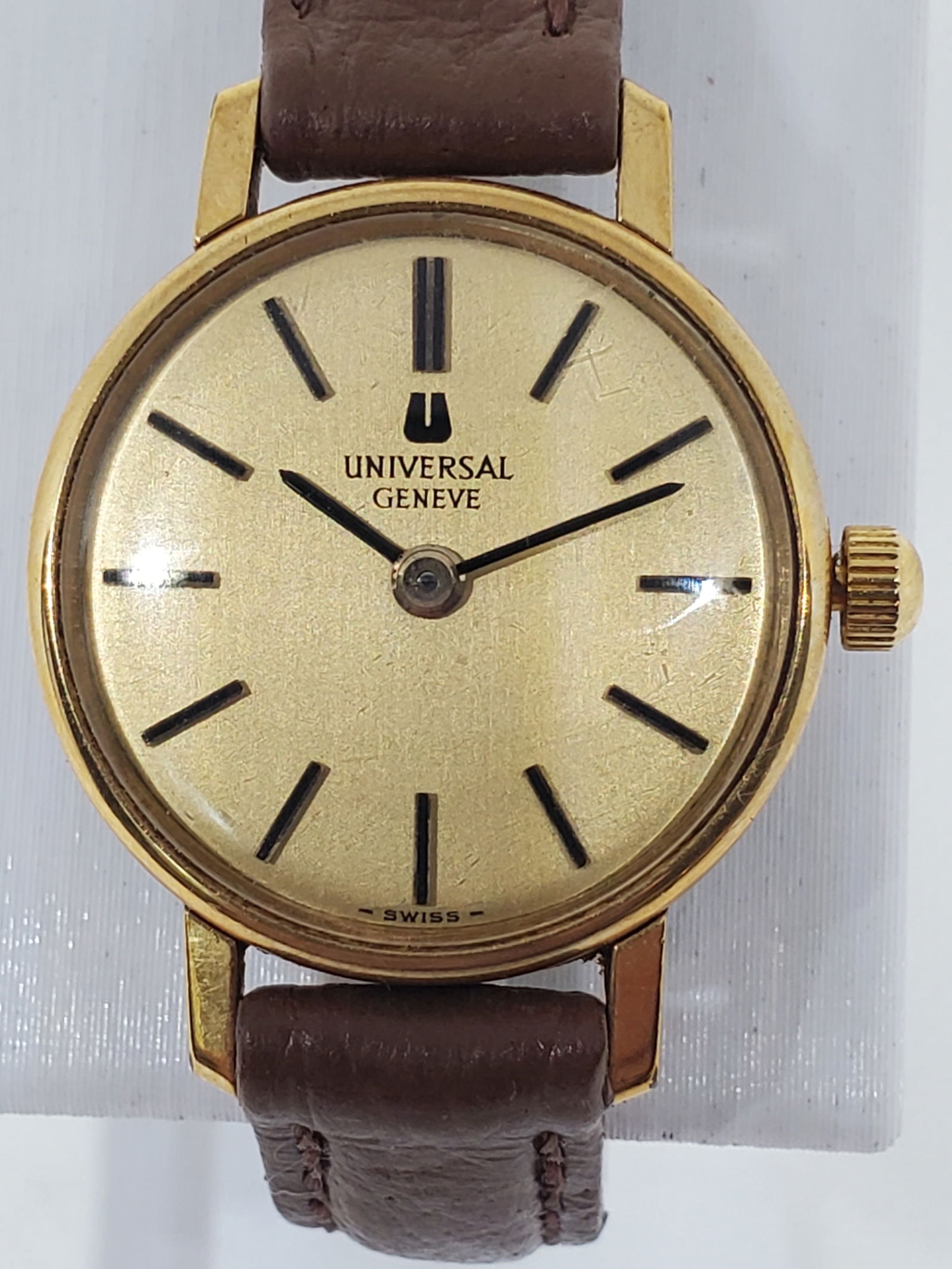Vintage Universal Geneve Manual Gold Dial Swiss Dress Watch 22mm, 1958: This elegant Universal Geneve dress watch showcases timeless Swiss prestige with a refined gold dial and slim gold plated case, powered by a classic manual wind movement that reflects traditional watc