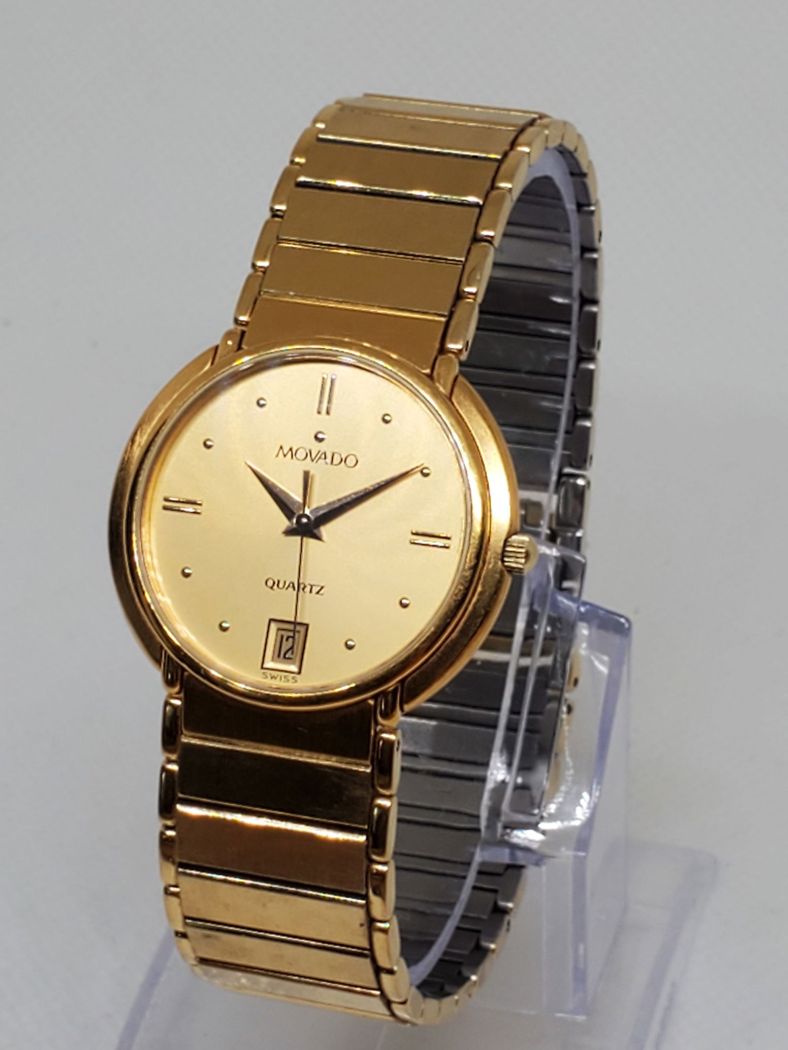 Movado Classic Gold Plated Watch 31mm, 1990s: This elegant Movado Classic 67 54 876 PV21P is a refined vintage dress watch, showcasing the brand?s minimalist design ethos. Housed in a 31mm gold plated case with a matching gold dial and discreet d
