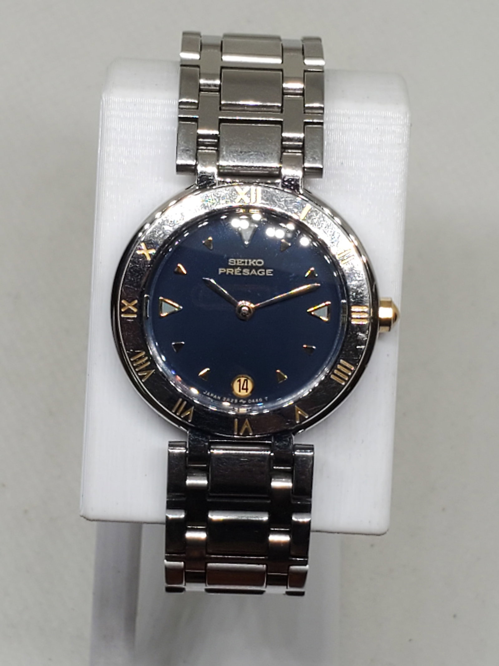 Seiko Presage Blue Dial Ladies Watch, 1990s: This Seiko Presage 2A29 0050 is a refined timepiece that embodies both elegance and subtle rarity. Its silver tone case, engraved Roman numeral bezel, and striking blue dial with gold tone markers cre
