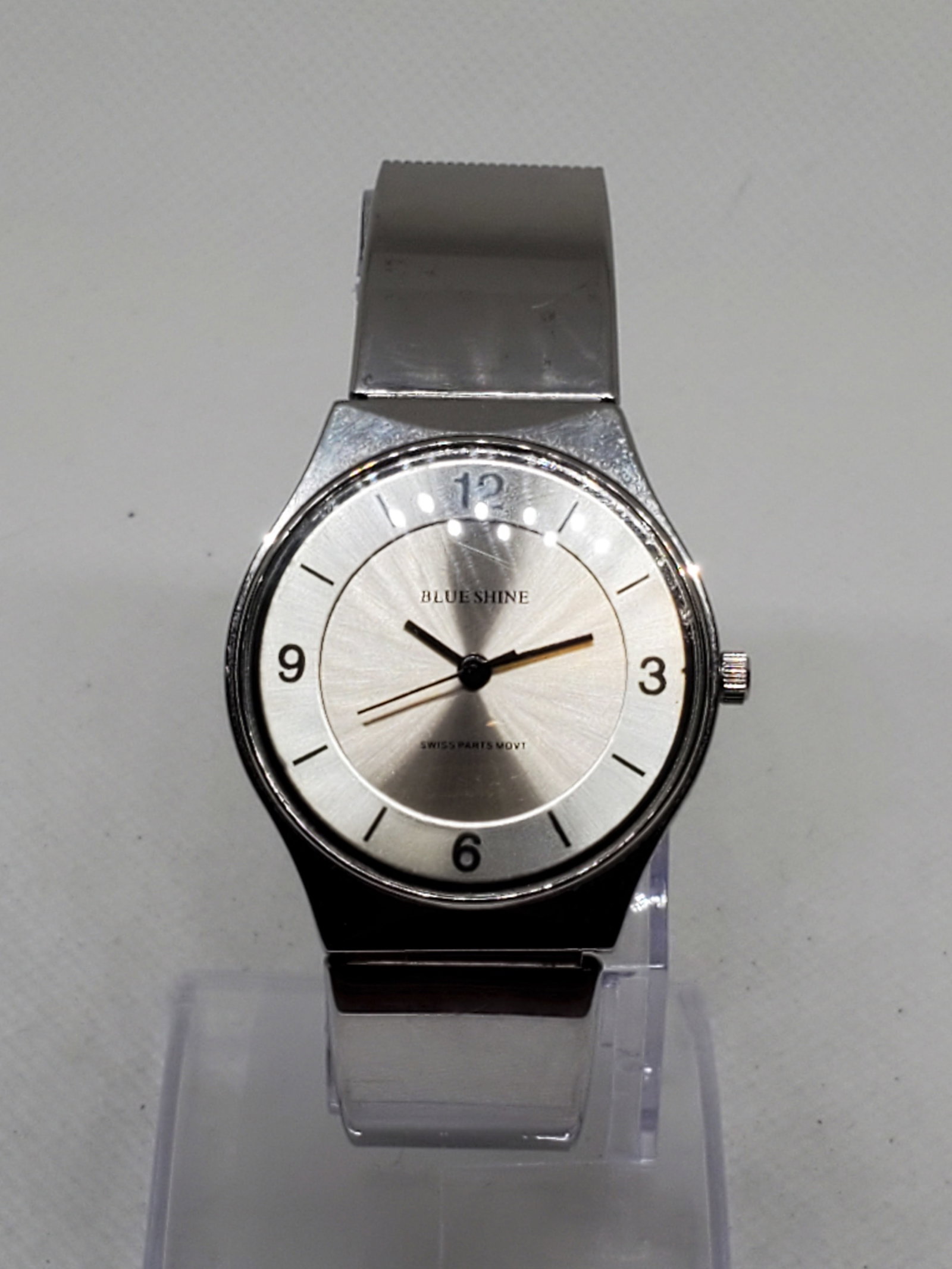Blue Shine Quartz Silver Mesh Watch Minimalist Swiss Parts Movement 32mm, 2000s: This Blue Shine Quartz wristwatch exudes sleek minimalist elegance with a durable silver tone case and a starburst silver dial that captures light beautifully. Its clean design and black numeral hour