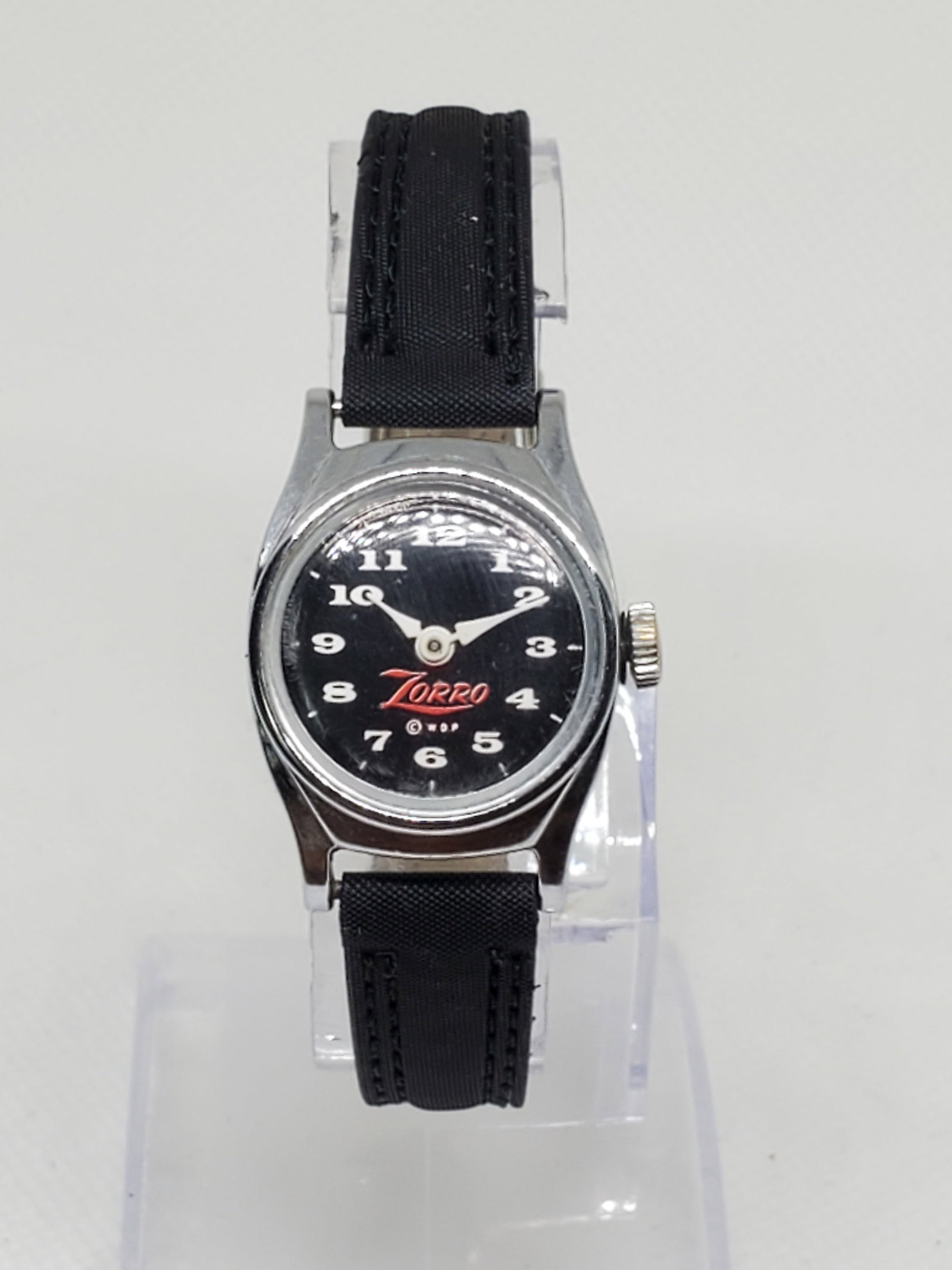 Disney Zorro Watch US Time, Manual, Chromium Plated, 1950s: Working condition US Time Disney Zorro watch, a rare find that beautifully blends fun with elegance. Featuring a striking Zorro logo on a black dial, this watch is powered by a reliable manual movemen