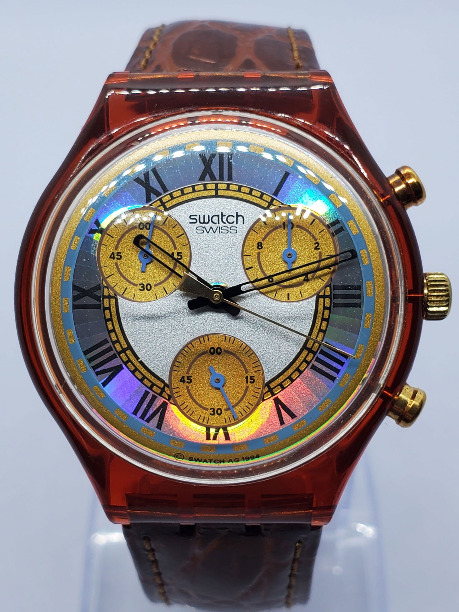 Swatch Hologram Chrono Red 1994 Mint Swiss Vintage, 1994: This Swatch SCF100 Hologram Chrono is a striking example of 1990s Swiss design innovation, featuring a translucent red plastic case paired with a textured silver dial and luminous holographic ring ado