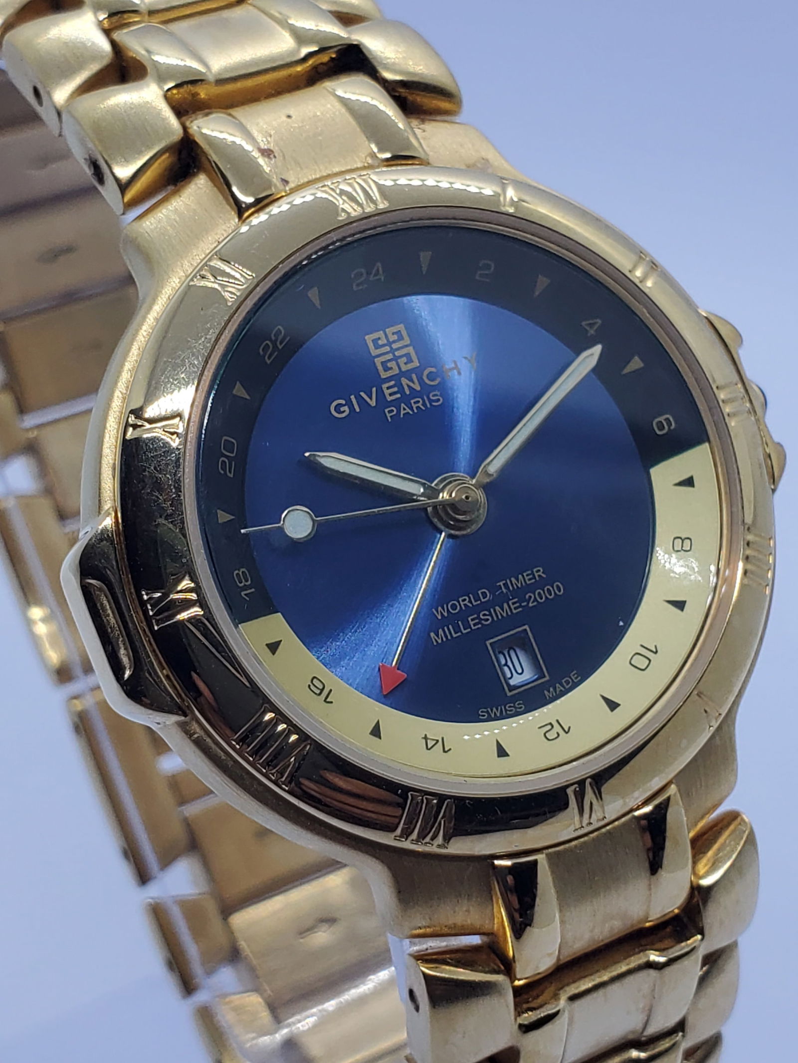 Givenchy Millesime 2000 World Timer Blue Dial Gold Plated Swiss Watch, 1990s: This elegant Givenchy Millesime 2000 quartz watch exemplifies refined Parisian luxury with a sophisticated Swiss made construction designed for both style and global practicality. Founded by Hubert de