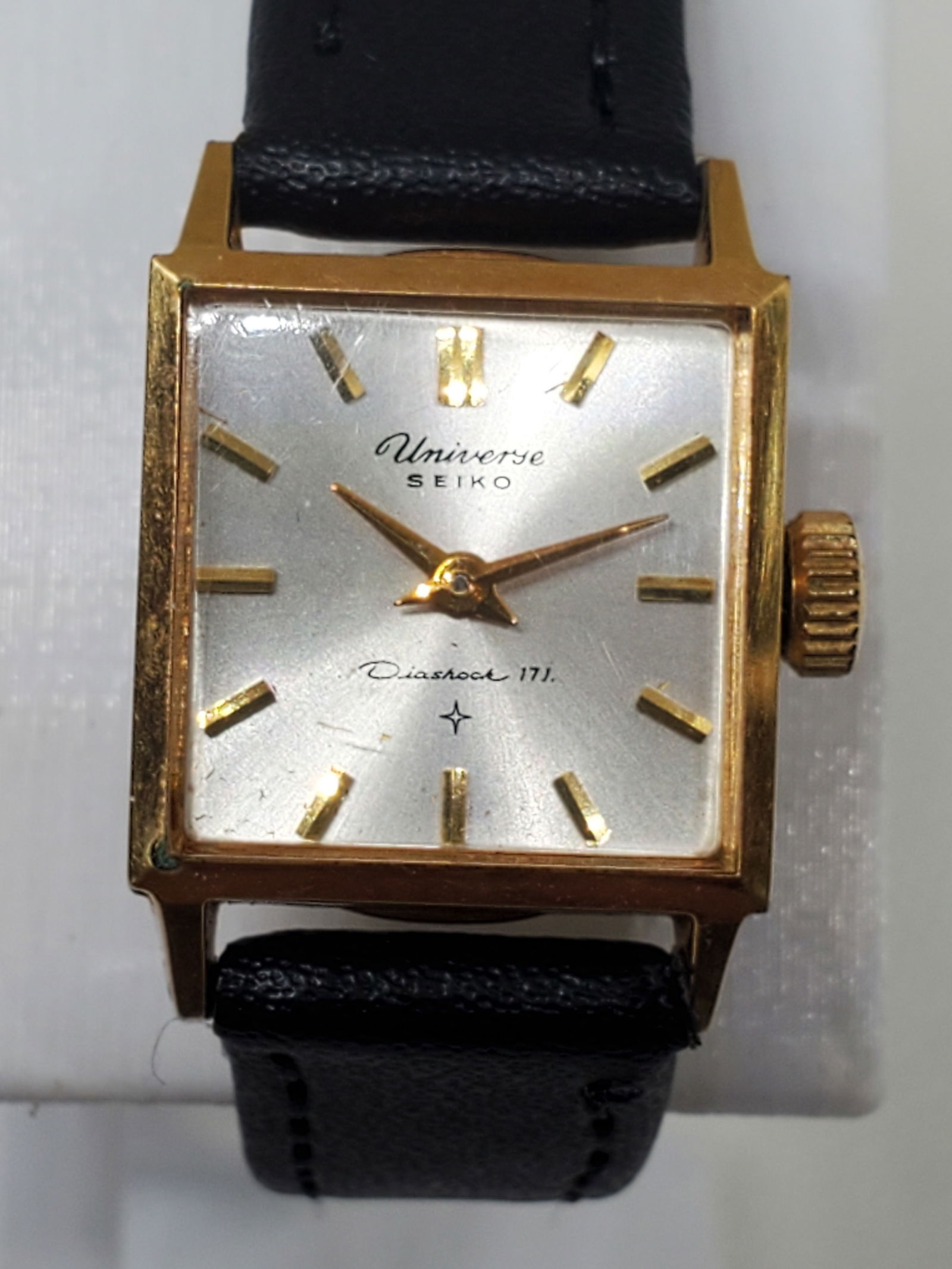 Seiko Universe Gold Plated Manual Watch, 1960s: This Seiko Universe 6015 embodies timeless elegance with its gold plated square case and refined sunburst silver dial. Powered by a precise manual movement with 17 jewels and Seiko?s Diashock protecti