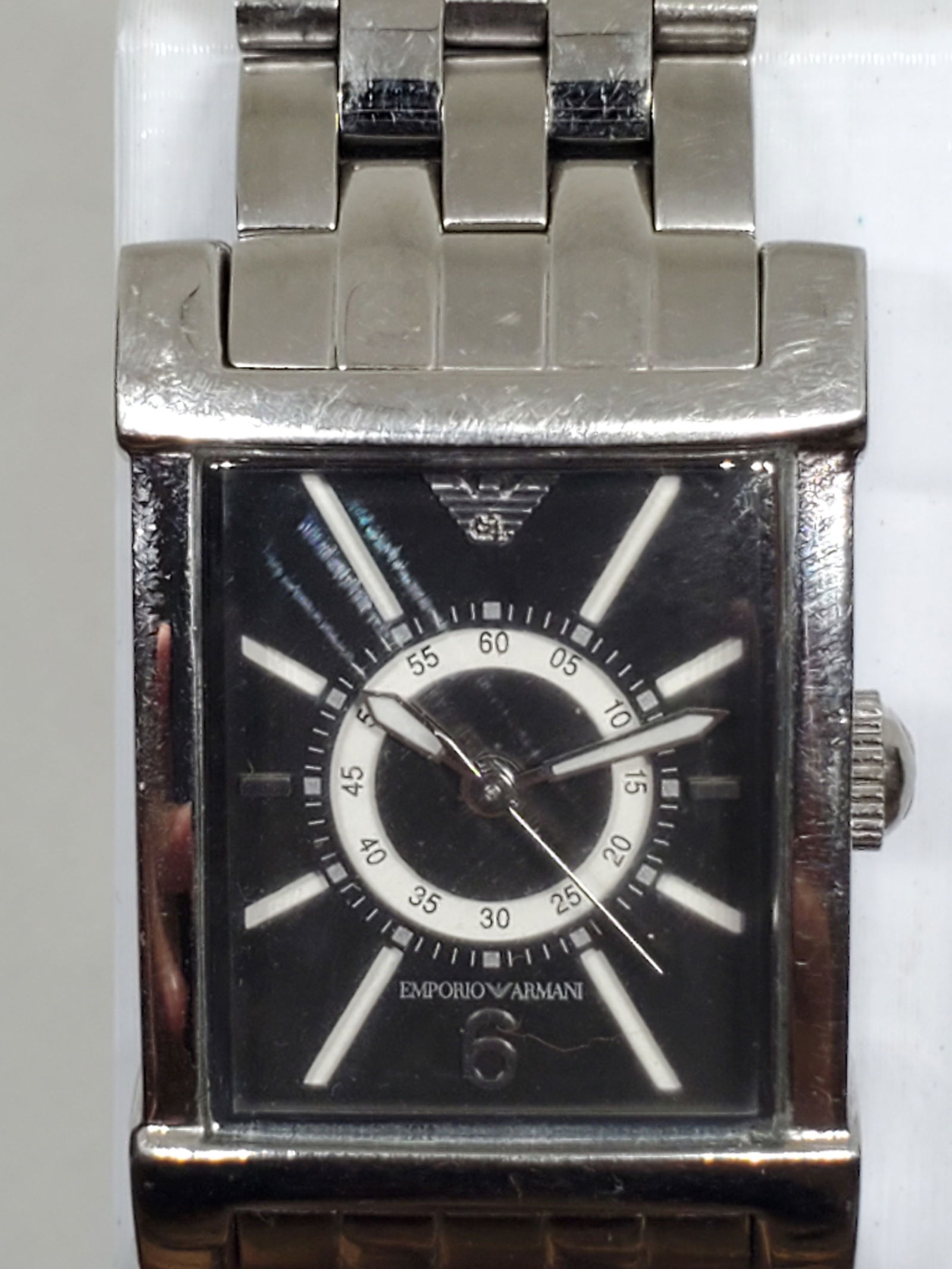 Emporio Armani AR 9006L Silver Dress Watch Black Dial 22mm x 33mm, 2010s, Working: This Emporio Armani AR 9006L quartz dress watch embodies elegance and prestige, designed for those who value refined style and durability. Featuring a sleek silver tone stainless steel case and a stri