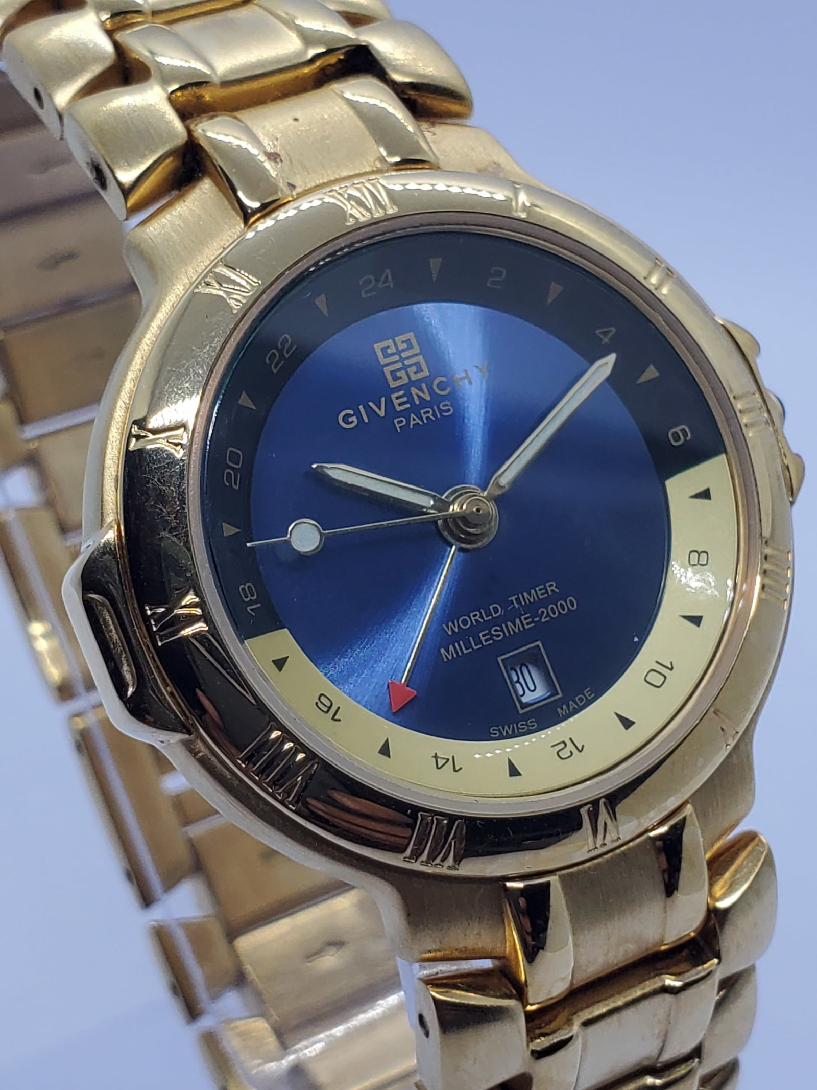 Givenchy Millesime 2000 World Timer Blue Dial Gold Plated Swiss Watch, 1990s, Working: This elegant Givenchy Millesime 2000 quartz watch exemplifies refined Parisian luxury with a sophisticated Swiss made construction designed for both style and global practicality. Founded by Hubert de
