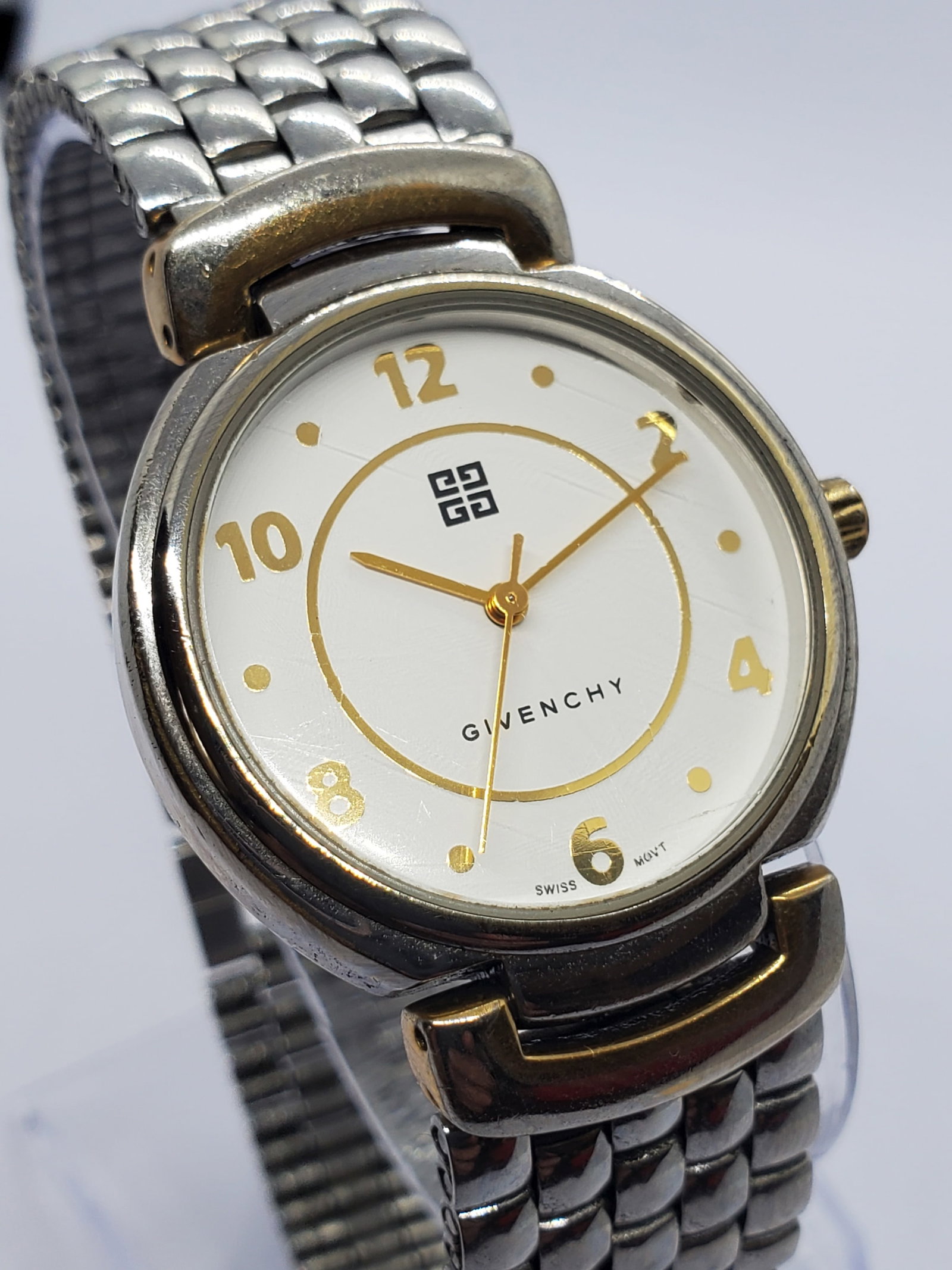 Vintage Givenchy Life Swiss Quartz Dress Watch 32 mm White Dial Gold Accents, 1990s, Working: Elegant and refined, this Givenchy Life 04 18 XV quartz dress watch showcases the timeless prestige of the Givenchy name, a brand founded by Hubert de Givenchy in 1952 in Paris and celebrated for its