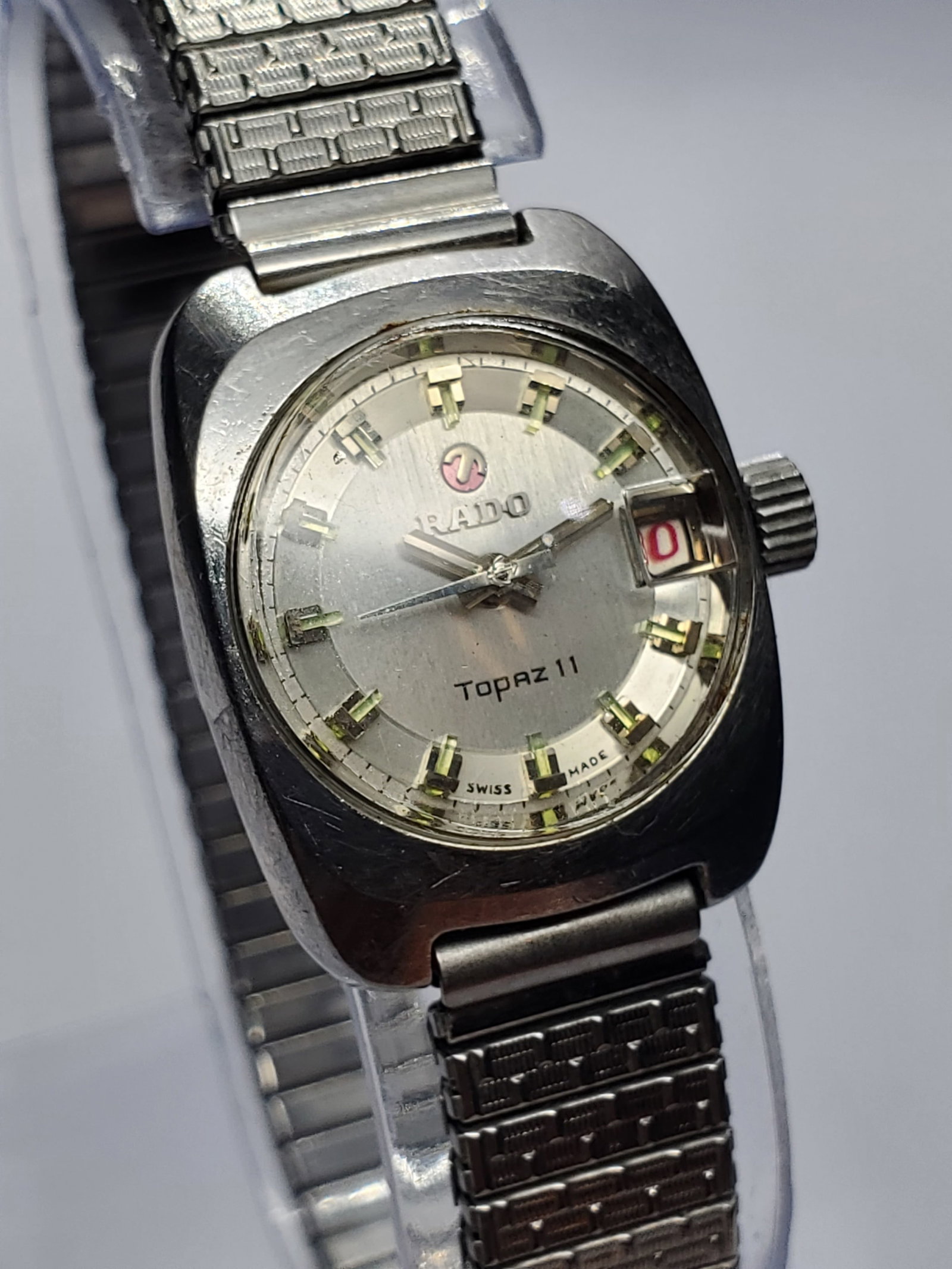 Rado Topaz II Automatic Date Cushion Case Swiss Dress Watch, 21x24mm, early 1970s, Working: This distinctive Rado Topaz II automatic watch reflects the bold yet elegant design language of vintage Swiss watchmaking. Featuring a compact silver tone cushion case measuring 21 mm by 24 mm, it sho