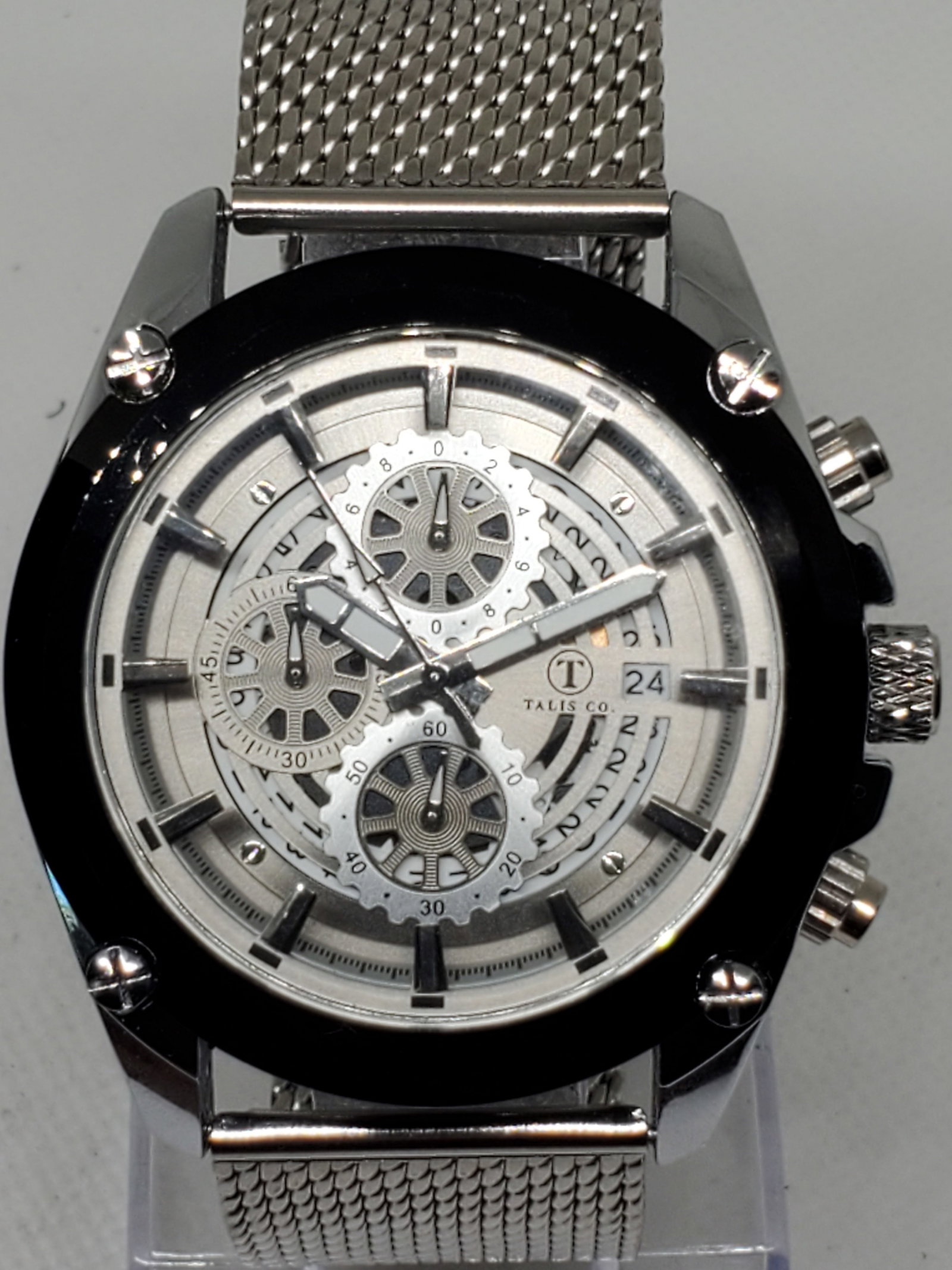 Talis Co. Chronograph Quartz Watch Skeleton Dial, Mesh Band, New in Box, Working: This elegant Talis Co. Chronograph watch blends modern craftsmanship with bold design. Featuring a 45mm silver tone case accented by a black bezel, it showcases a skeleton dial with functional minutes