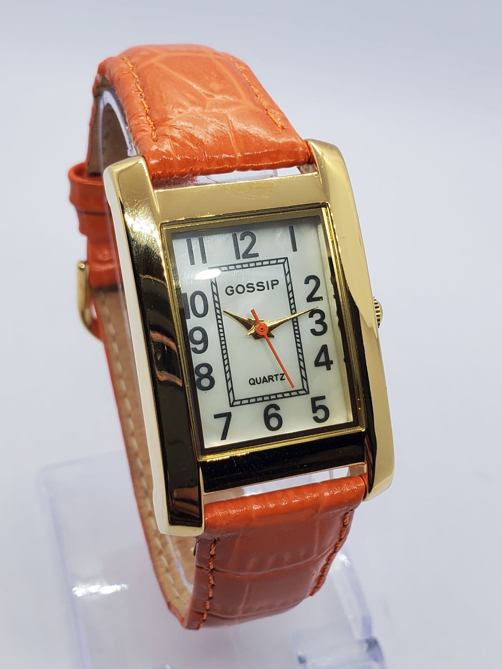 Gossip Gold Tone Tank Watch MOP Dial New in Box, 2005 to 20215, Working: This Gossip 173D quartz watch presents a refined dress style with a gold tone rectangular tank case 18 mm x 24 mm and an elegant mother of pearl dial accented by bold Arabic numerals and a contrasting