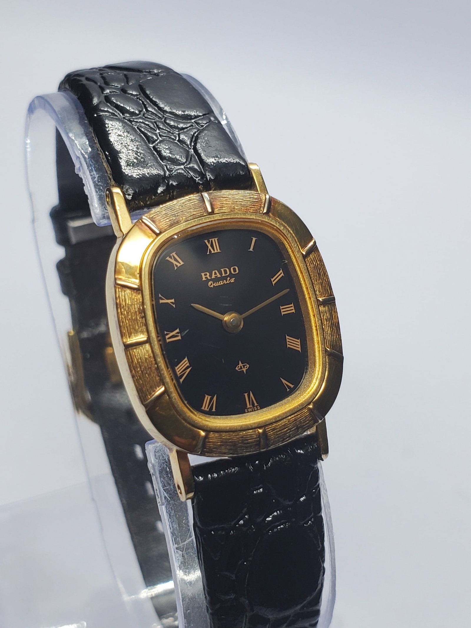 Vintage Rado Gold Plated Black Dial Quartz Watch, 20x23mm, circa 1990, Working: Elevate your collection with this elegant vintage Rado Quartz dress watch, model 700.9037.2, a refined Swiss timepiece that blends minimalist luxury with timeless sophistication. Founded in 1917 in Le
