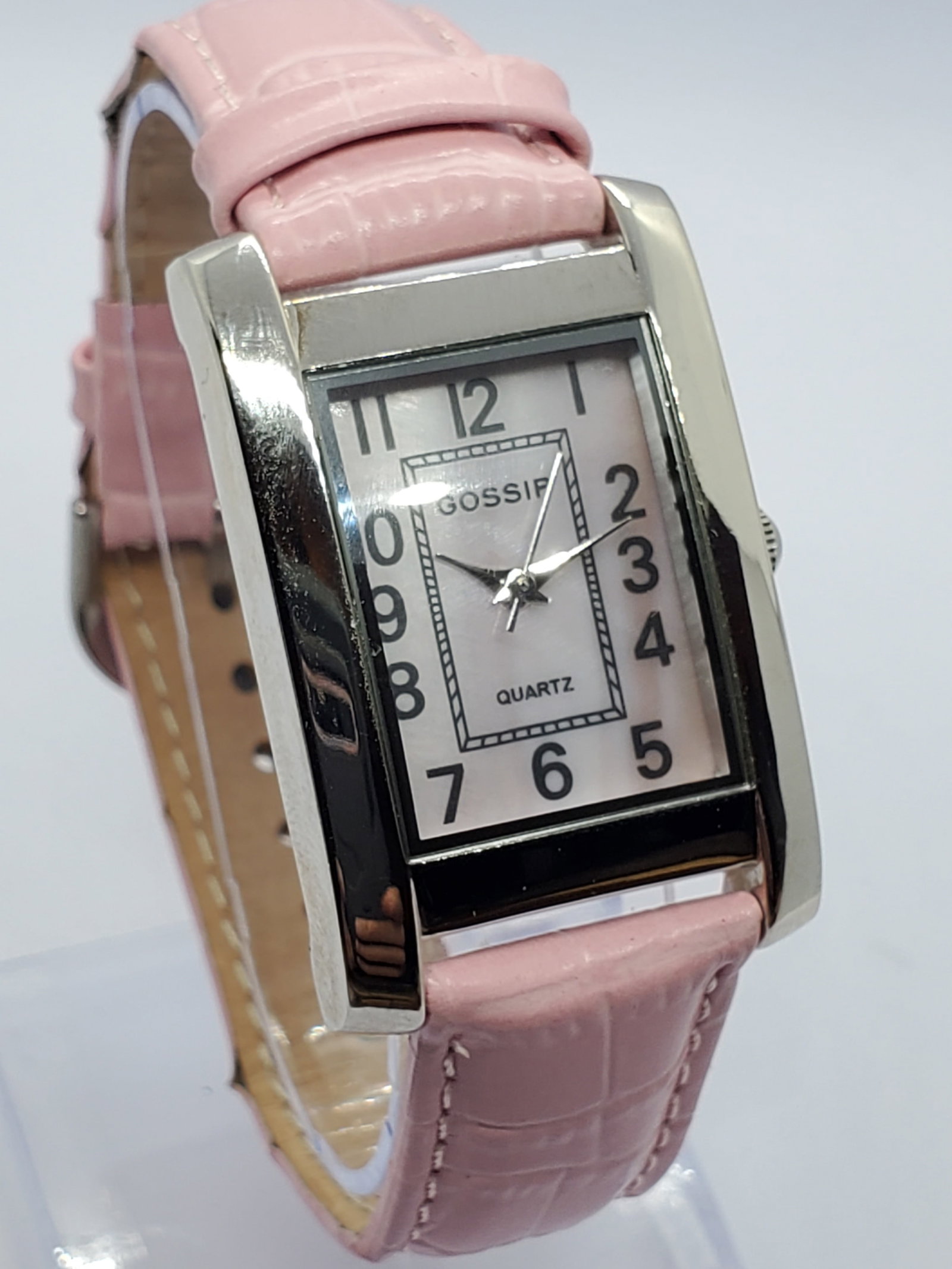 Gossip Silver Tone Tank Watch MOP Dial New in Box, 2005 to 20215, Working: This Gossip 172D quartz watch presents a refined dress style with a silver tone rectangular tank case 18 mm x 24 mm and an elegant mother of pearl dial accented by bold Arabic numerals and a contrasti