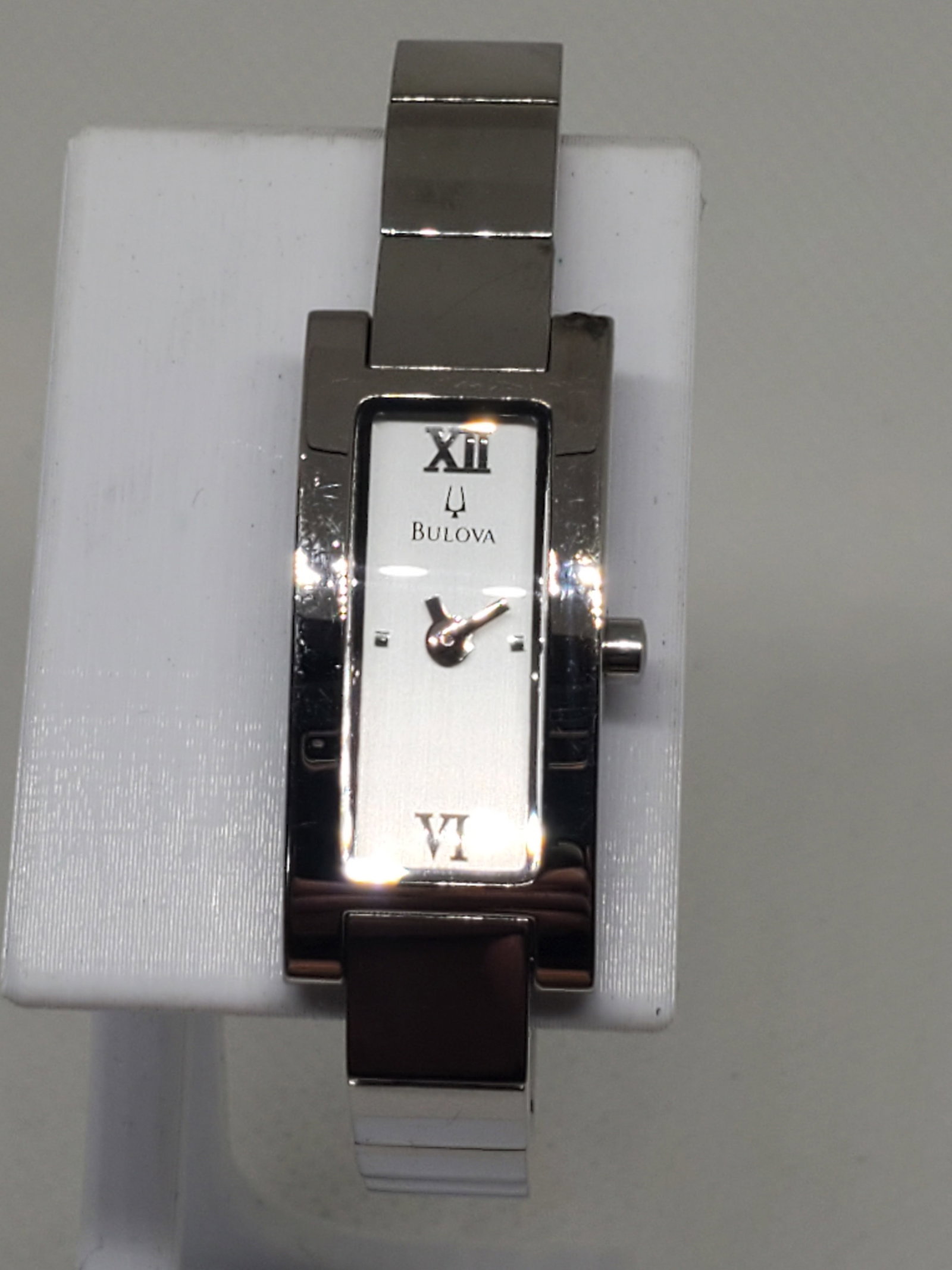 Bulova Dual Tone Gold Plated ladies Watch, 2006, Working: Elevate your style with this elegant Bulova C865118 dress watch, featuring a refined silver tone case and a minimalist silver dial that exudes classic sophistication. Its compact 14mm x 24mm rectangul