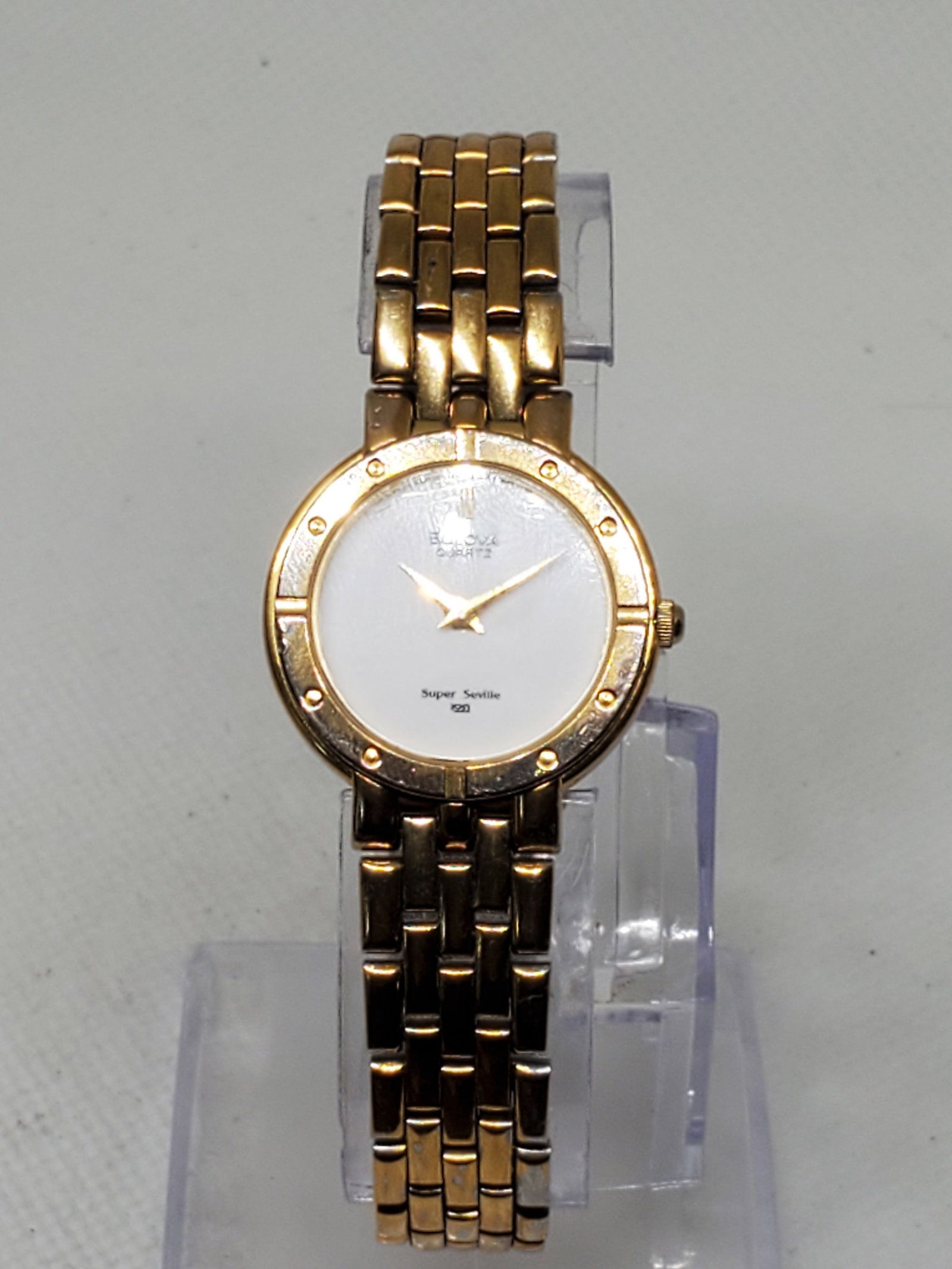 Bulova Super Seville Gold Plated Ladies Watch, 1980s, Working: Experience the refined elegance of the Bulova Quartz Super Seville, model 839401140. This sophisticated dress watch features a gold plated case paired with a pristine white dial, exuding timeless char