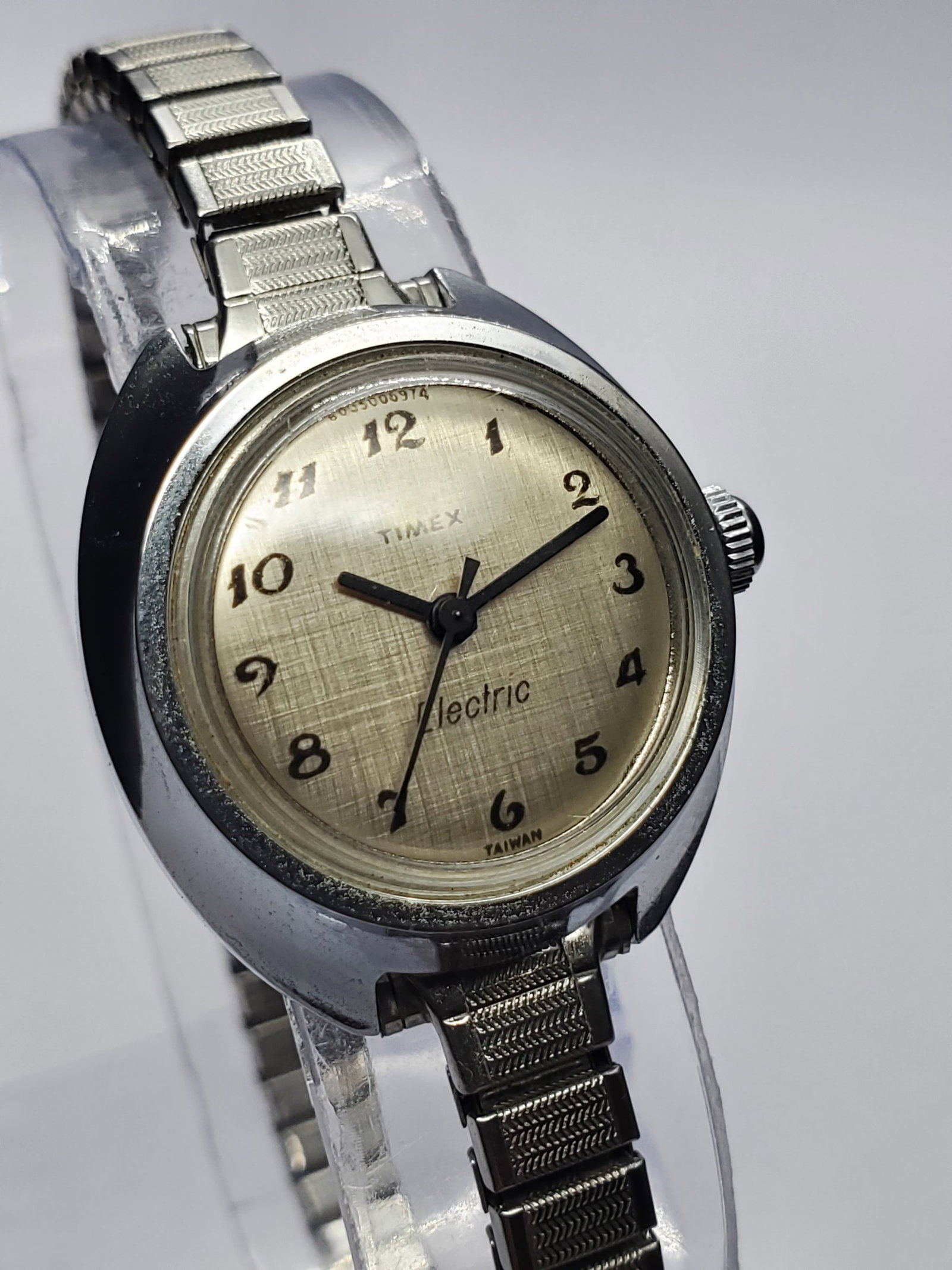 Vintage Timex UFO Electric Electro Mechanic Watch, 25mm, 1974, Running: Discover the unique charm of this vintage Timex Electric electro mechanic dress watch featuring a silver tone UFO-shape case, elegant silver linen textured dial, and a classic 25 mm profile complement