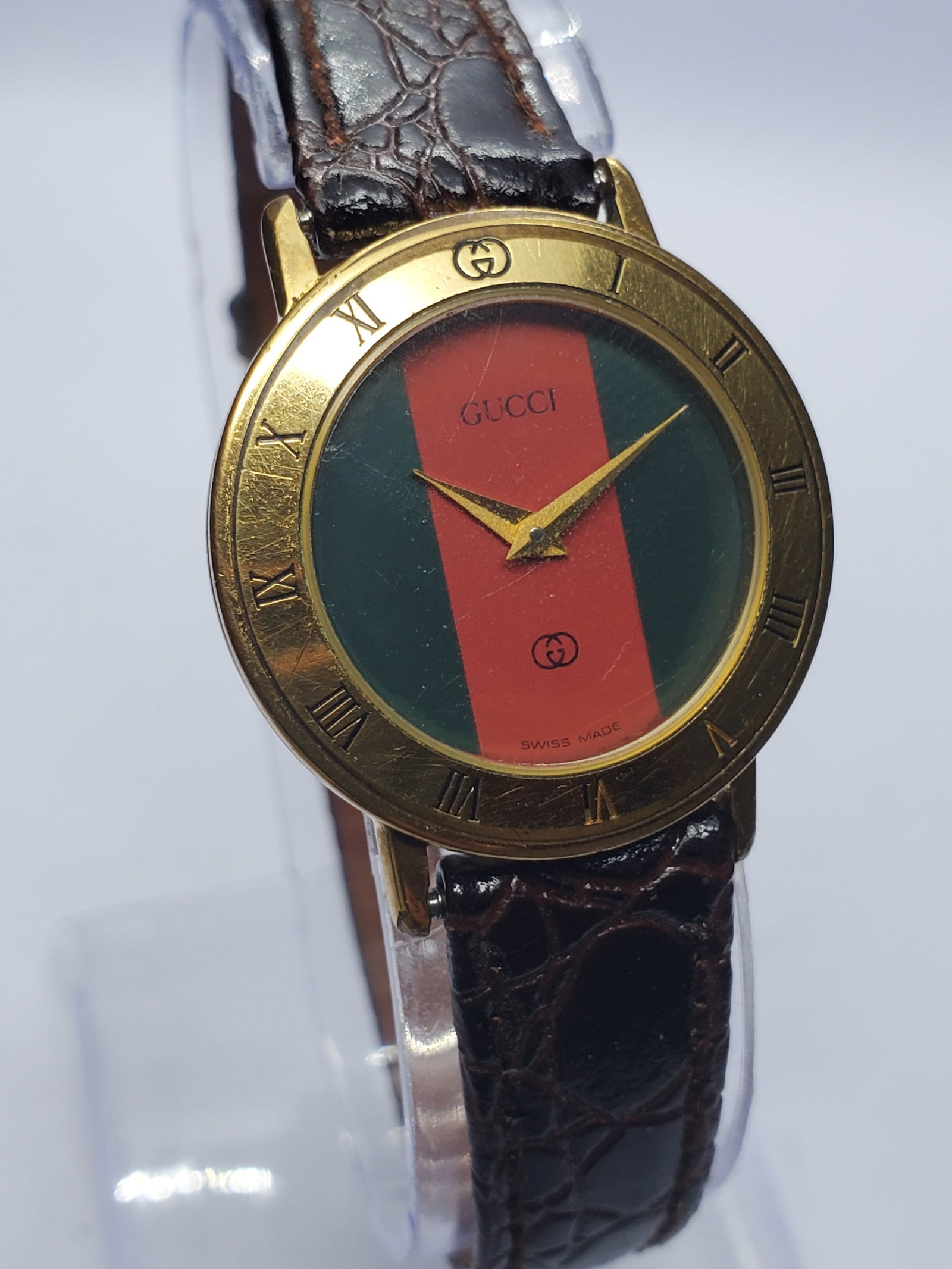 Vintage Gucci 3001L Sherry Line Swiss Gold Tone Green and Red Stripes Watch, 26mm, 1990s, Running: Experience timeless Italian luxury with this vintage Gucci 3001L quartz dress watch, a highly recognizable example of the brand?s iconic Sherry Line collection. Founded by Guccio Gucci in Florence, It