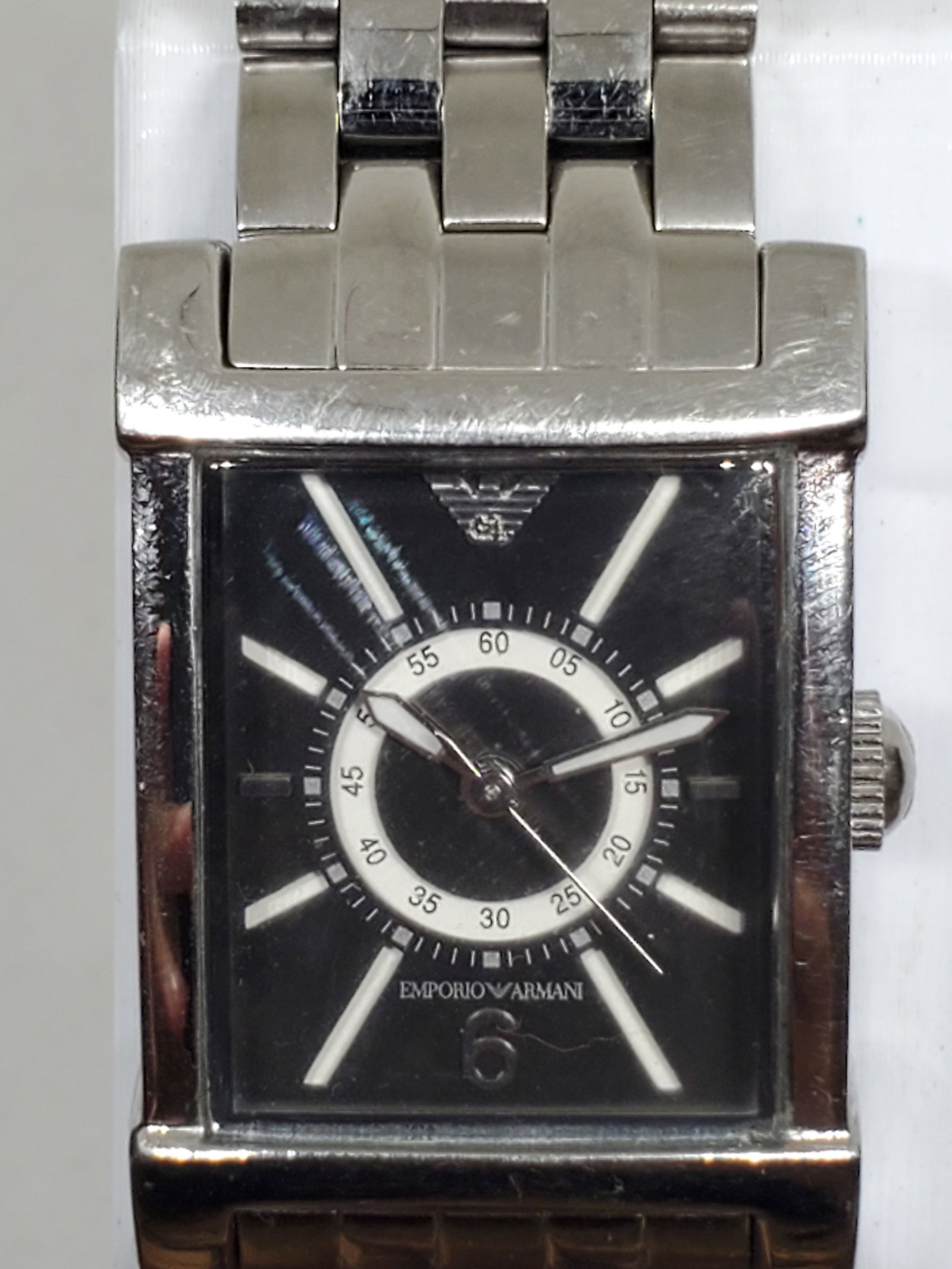 Emporio Armani AR 9006L Silver Dress Watch Black Dial 22mm x 33mm, 2010s, Running: This Emporio Armani AR 9006L quartz dress watch embodies elegance and prestige, designed for those who value refined style and durability. Featuring a sleek silver tone stainless steel case and a stri