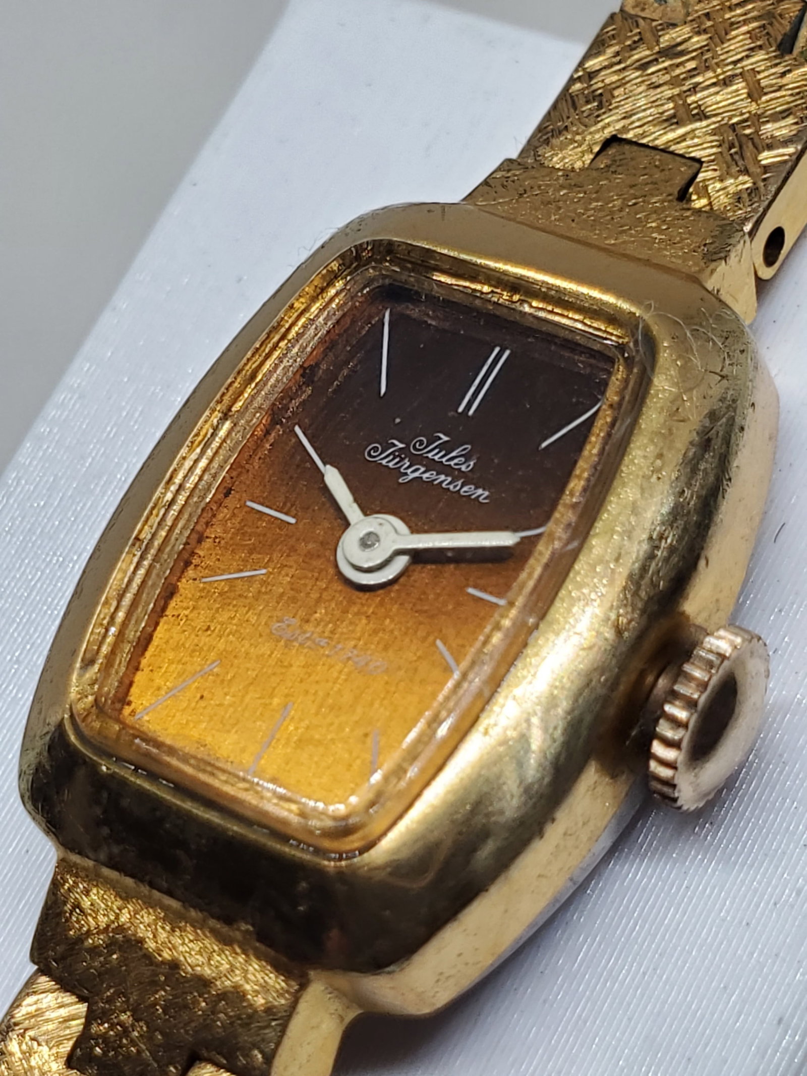Vintage Jules Jurgensen 5614 Vintage Gold Tone Manual Dress Watch Bronze Tone Dial, 1962, Running: This elegant Jules Jurgensen Model 5614 dress watch showcases classic prestige with a gold plated case and a refined bronze dial accented by clean markers, offering timeless style for formal wear or e