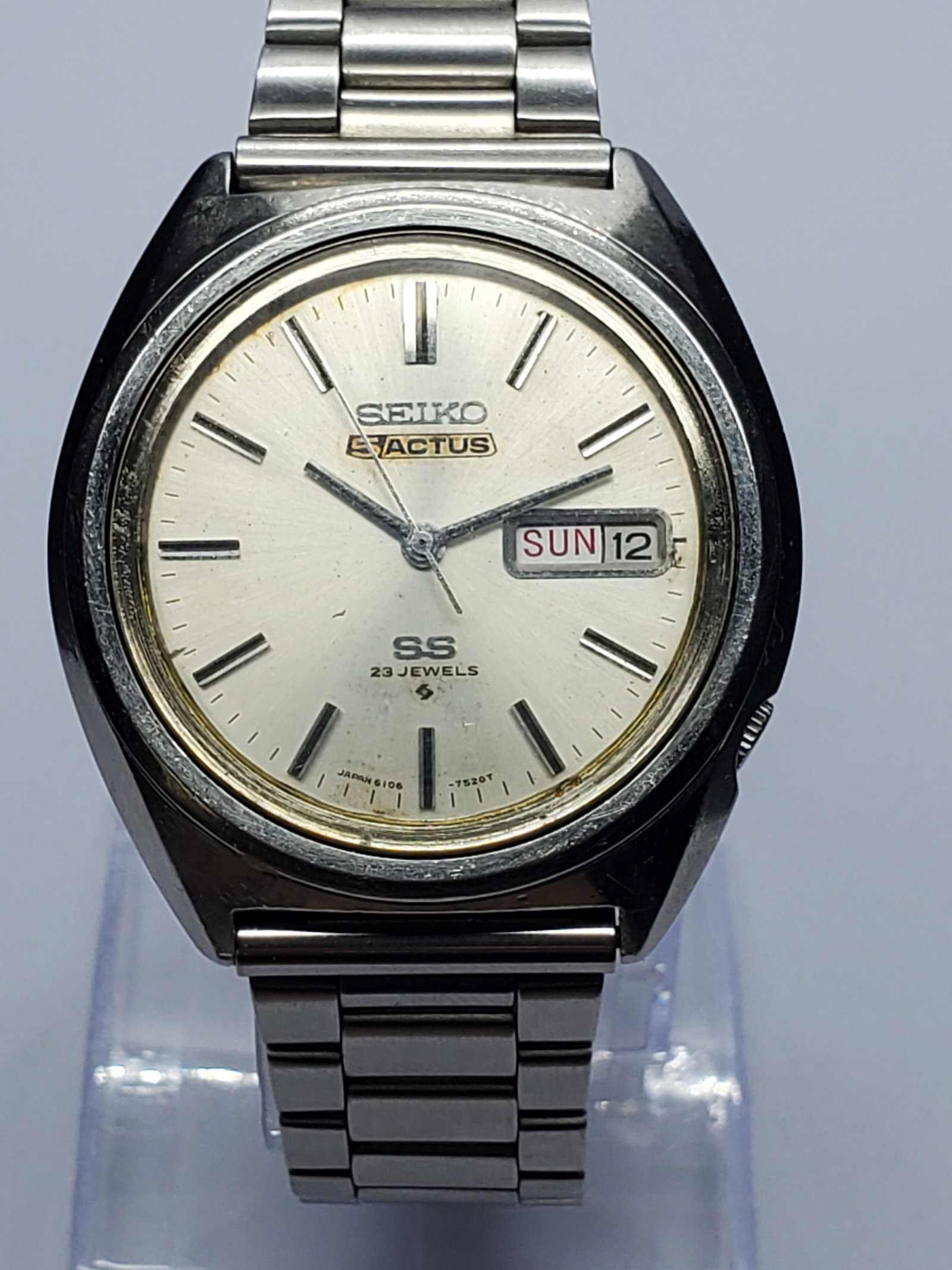 Vintage Seiko 5 Actus SS 6106-7520 Automatic, 38mm, 1971, Running: Experience the timeless craftsmanship of this Seiko 5 Actus SS 6106-7520 Automatic, a classic Japanese dress watch featuring a silver tone stainless steel case, elegant sunburst silver dial, day and d
