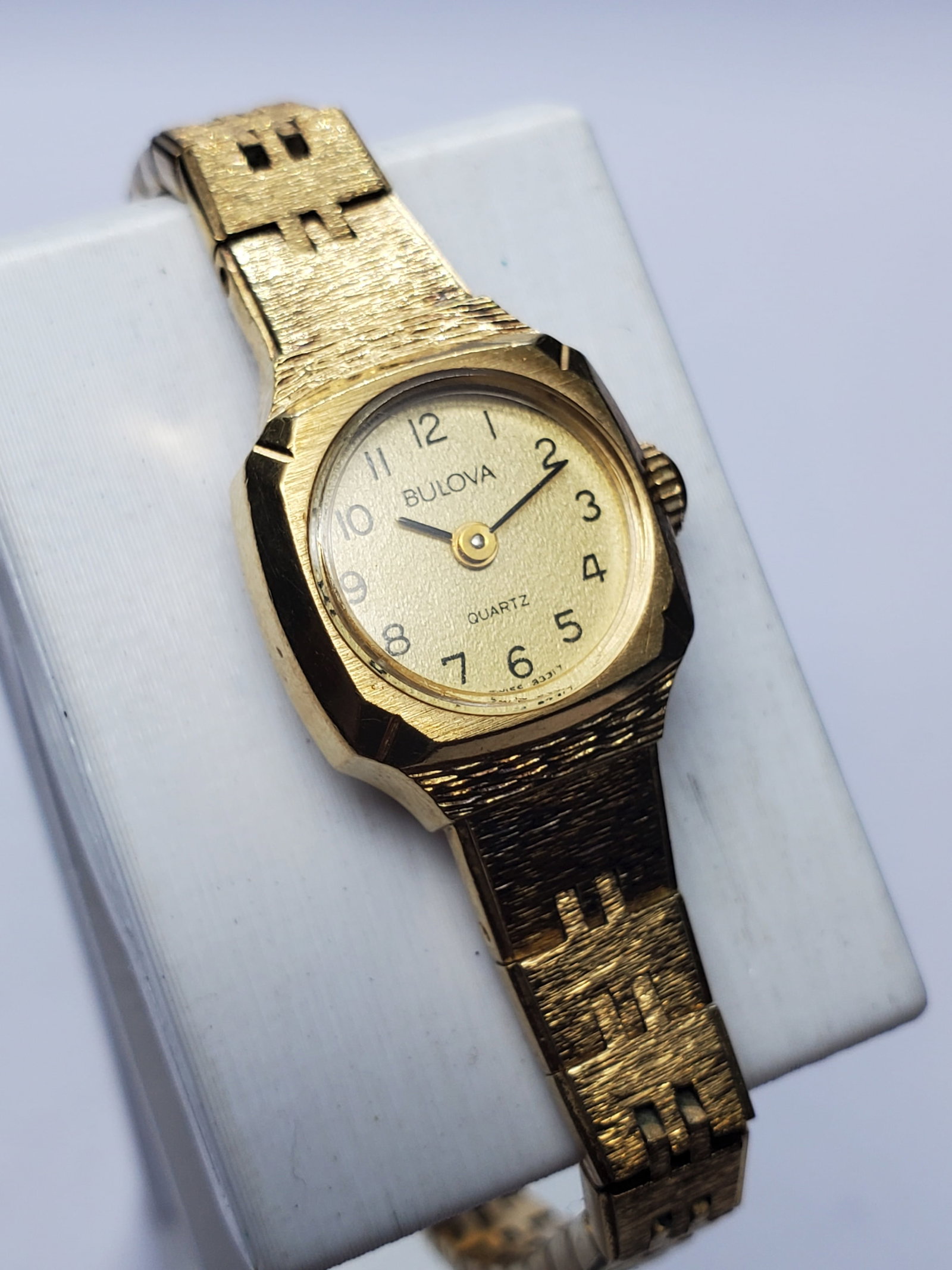 Vintage Bulova P3 Gold Tone Swiss Dress Watc18x19mm, 1980s, Running: Discover timeless elegance with this vintage Bulova P3 Quartz Dress Watch, a refined ladies timepiece featuring a gold tone case, textured gold tone dial, and matching metallic bracelet measuring 6.5 