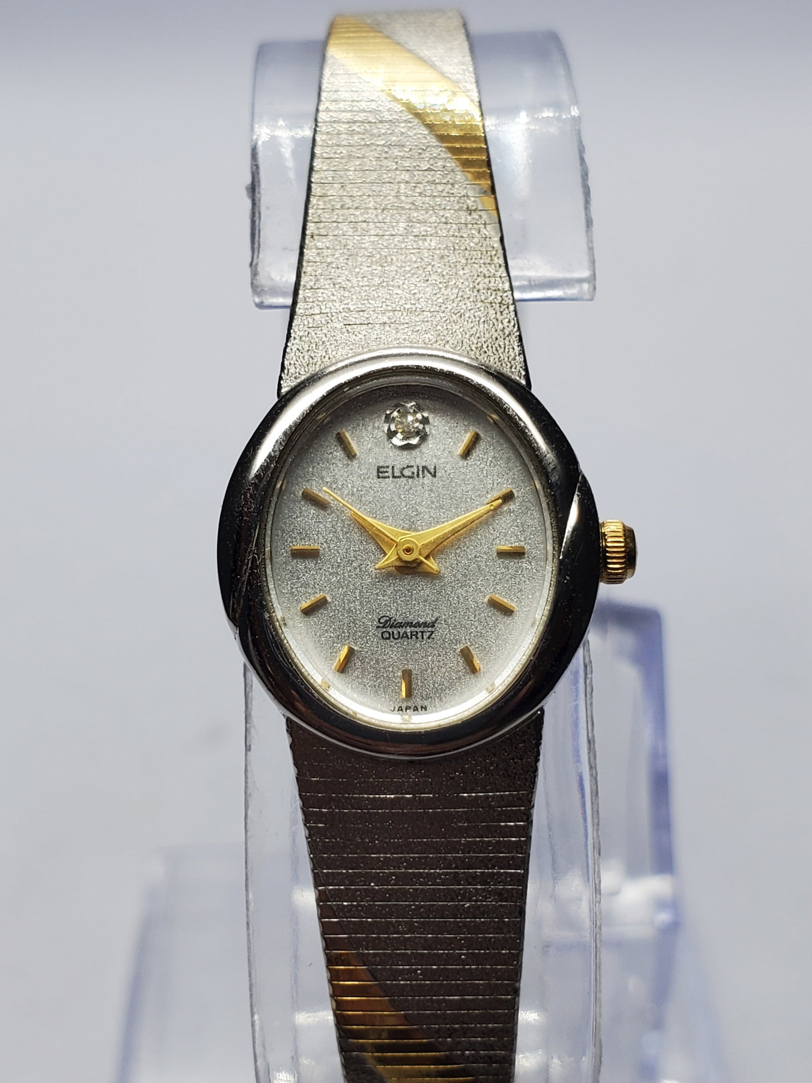 Vintage Elgin Diamond Dress Watch Dual Tone Bracelet, 17x19mm, 1990s, Running: Elegant vintage Elgin EK 509 007 quartz dress watch featuring a silver tone case, refined sanded silver dial accented with a genuine diamond at 12 o clock, gold tone hands and hour markers, and a styl