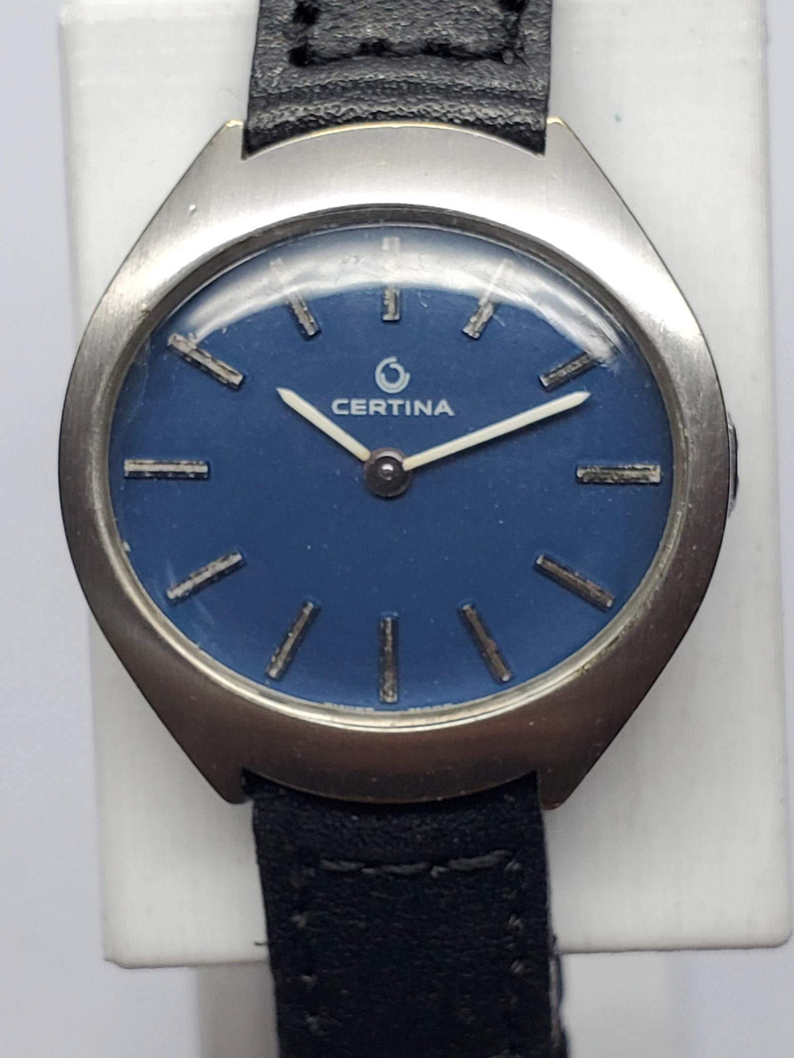 Vintage Certina Manual Blue Dial Cushion Case Swiss Dress Watch, 1968 to 1974, Running: This elegant Certina Classic manual wind dress watch embodies refined Swiss craftsmanship and understated vintage sophistication. The watch features a distinctive silver tone cushion style case measur