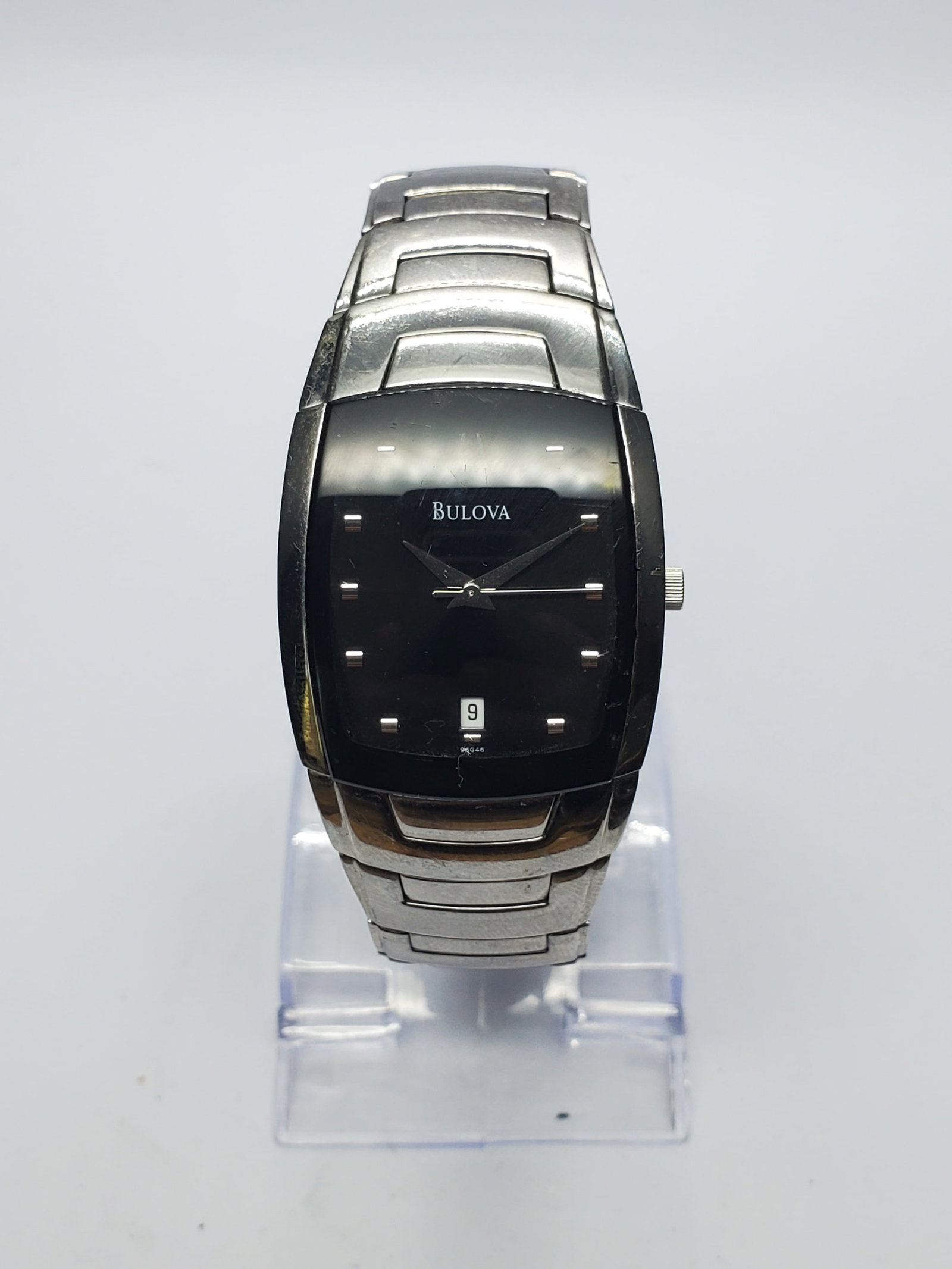Bulova Tonneau Black Dial Mens Watch, 30x40mm, 2000s, Running: Distinctive Bulova 96G46 men?s quartz dress watch featuring a 30 x 40 mm silver-tone tonneau case, sophisticated black dial, silver-tone markers and hands, date window, and a 7-inch metallic bracelet.