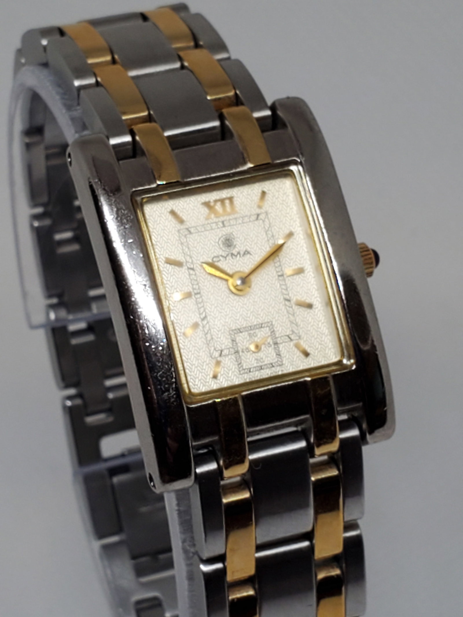 Vintage Cyma Sealord Dul Tone Watch, year 1980s, Running: Introducing the Cyma Sealord 730, a watch that embodies elegance and timeless prestige running . With its quartz movement and a sleek rectangular 21 mm x 23 mm case with gold tone dial that contain a 
